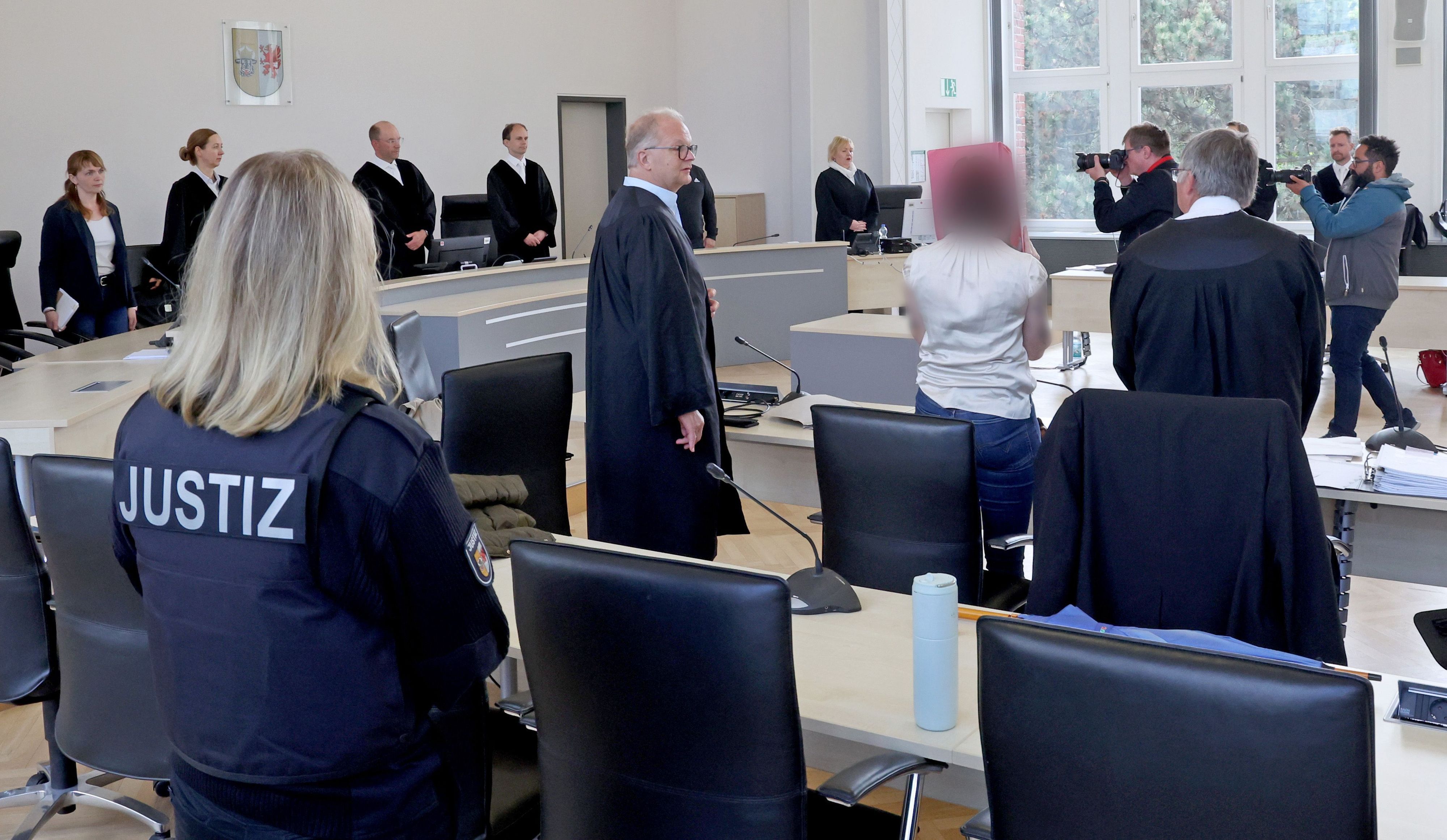 Eine Justizmitarbeiterin (l-r), Thomas Löcker, Anwalt, die Angeklagte und Andreas Ohm, Anwalt, stehen im Saal des Landgerichts zu Beginn der Fortsetzung des Mordprozesses.