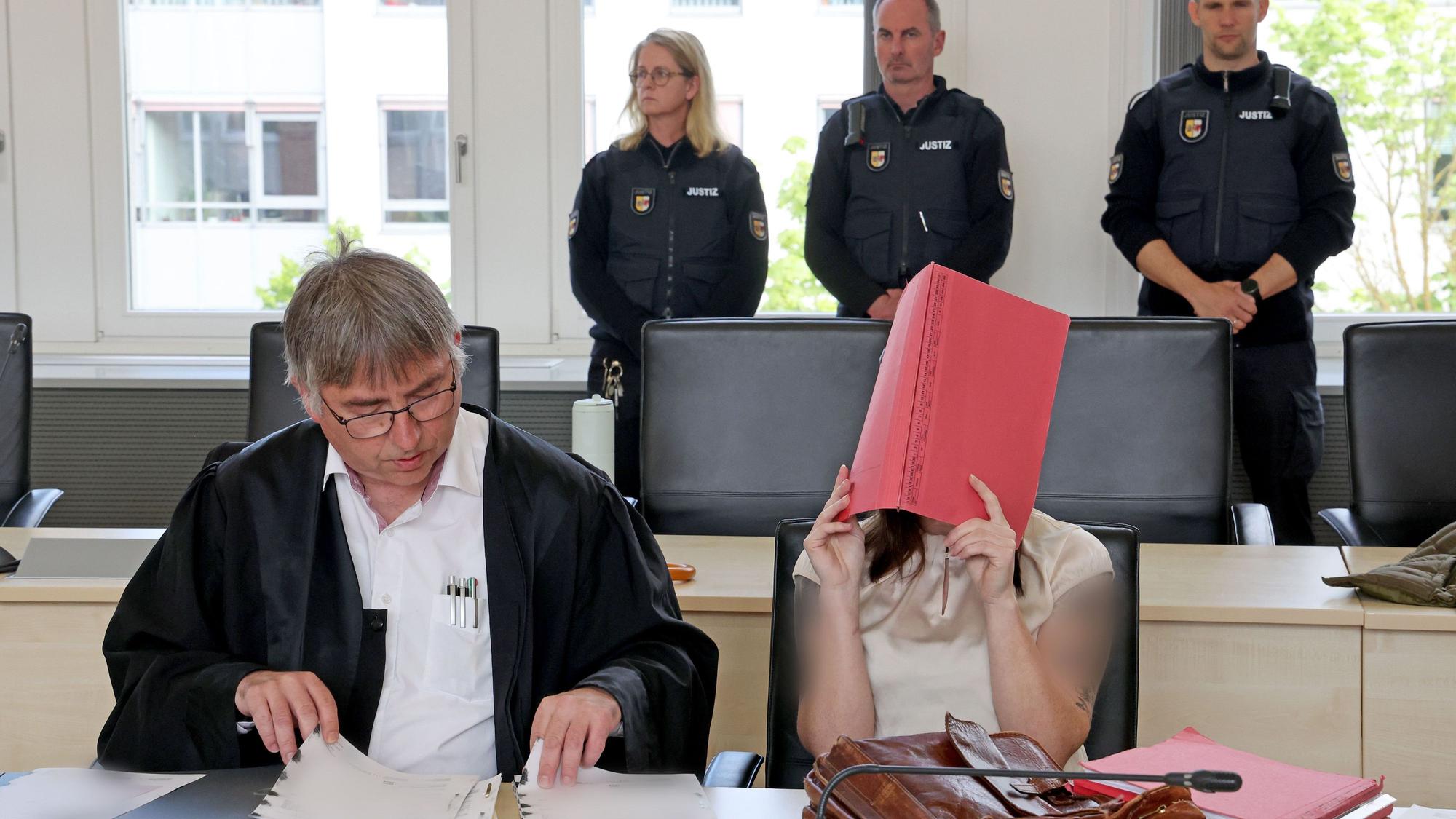 Andreas Ohm (l), Anwalt, und die Angeklagte warten im Saal des Landgerichts auf die Fortsetzung des Mordprozesses.