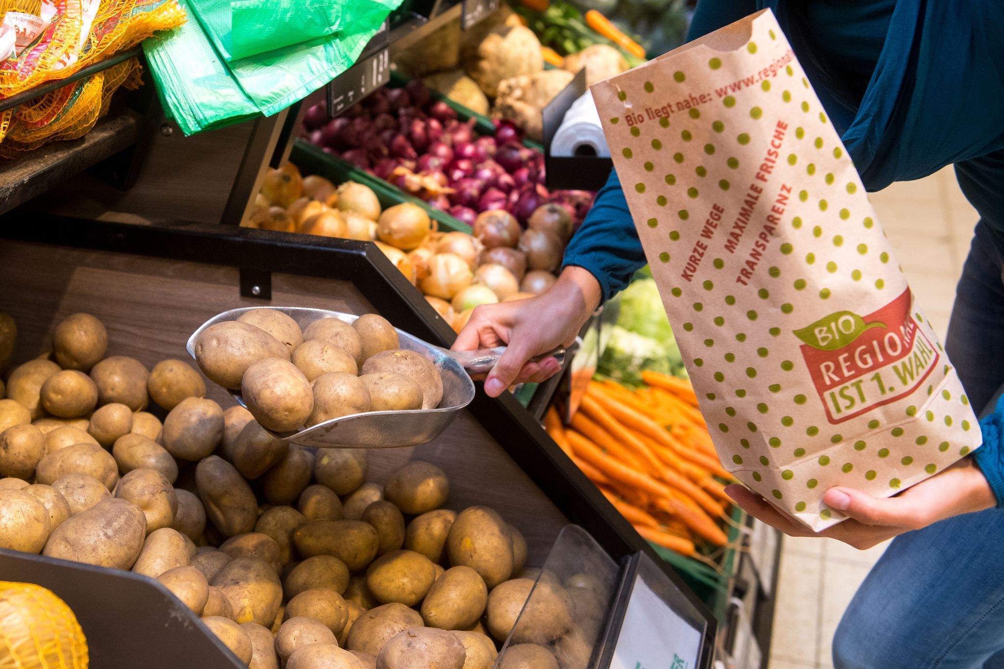 Eine Frau füllt Kartoffeln in eine Papiertüte