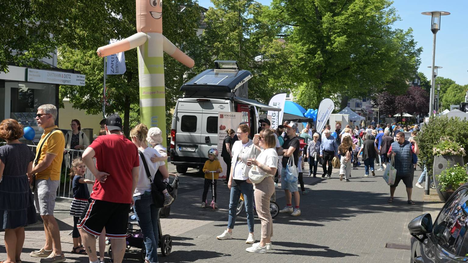 Menschen gehen an Ständen vorbei.