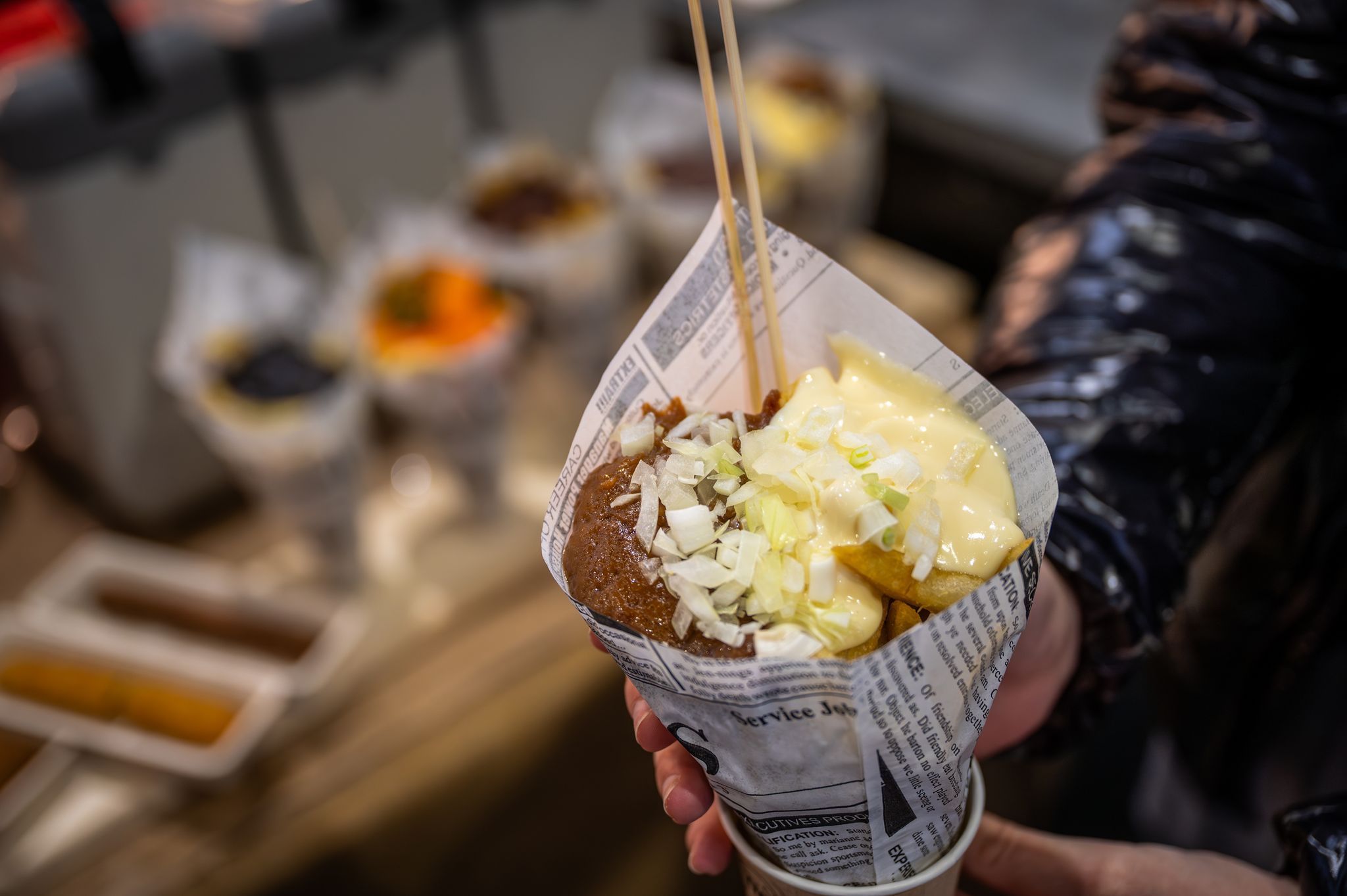 Eine Messebesucherin hält eine Tüte Pommes in der Hand