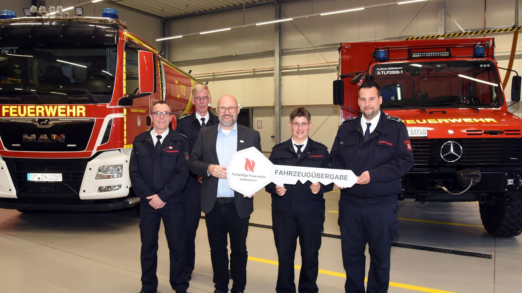 Zu sehen ist die symbolische Schlüsselübergabe für zwei neue und umgebaute Feuerwehr-Fahrzeuge an Vertreter der Freiwilligen Feuerwehr Nümbrecht.
