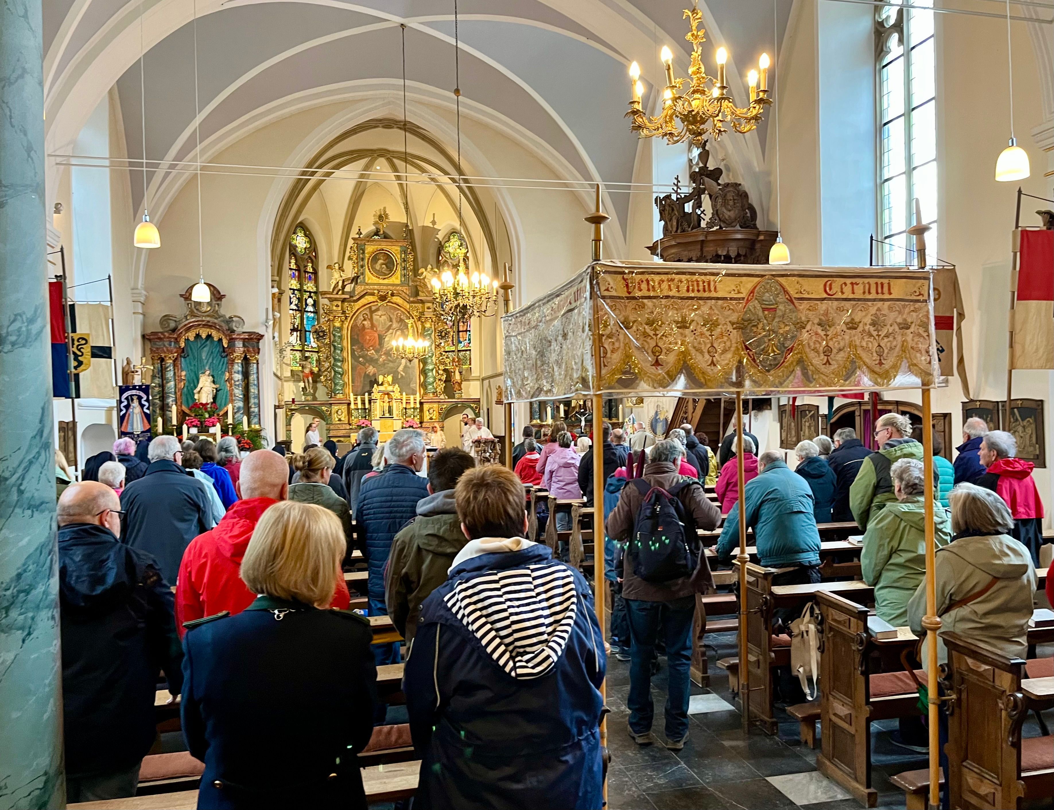 Menschen stehen in einer Kirche.