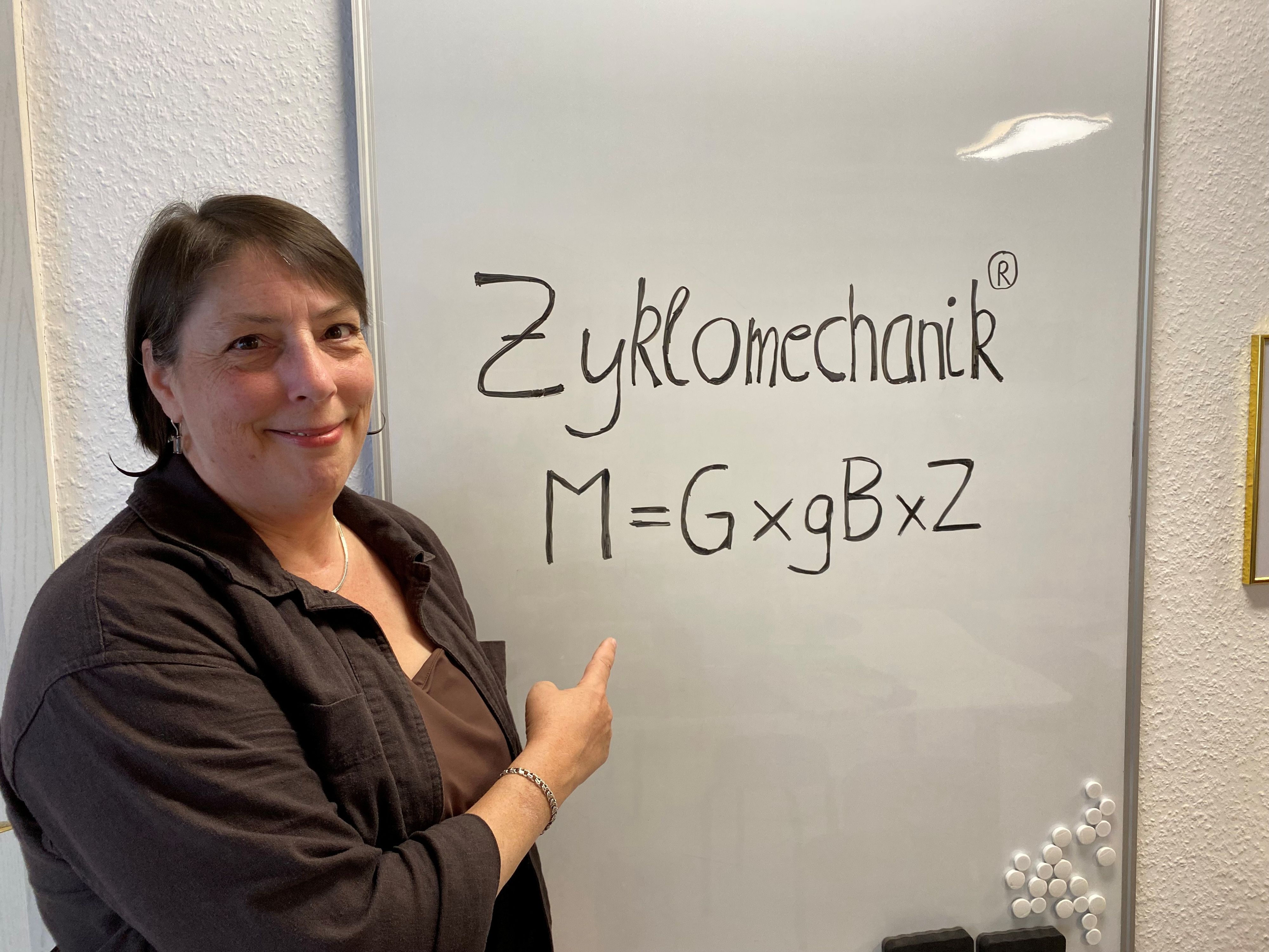 Eine Frau zeigt auf ein Plakat, auf dem steht Zyklomechanik
