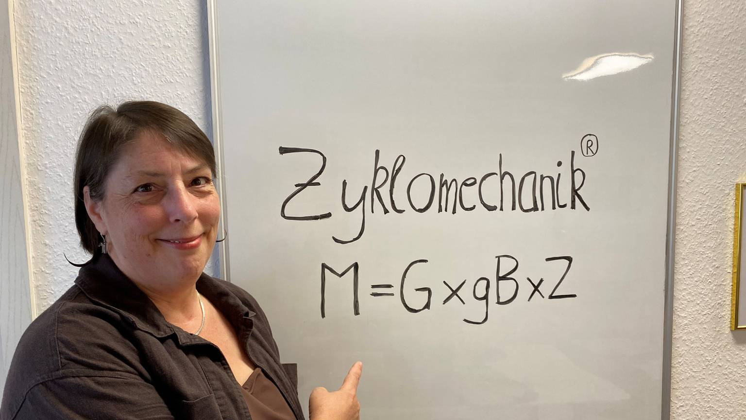 Eine Frau zeigt auf ein Plakat, auf dem steht Zyklomechanik