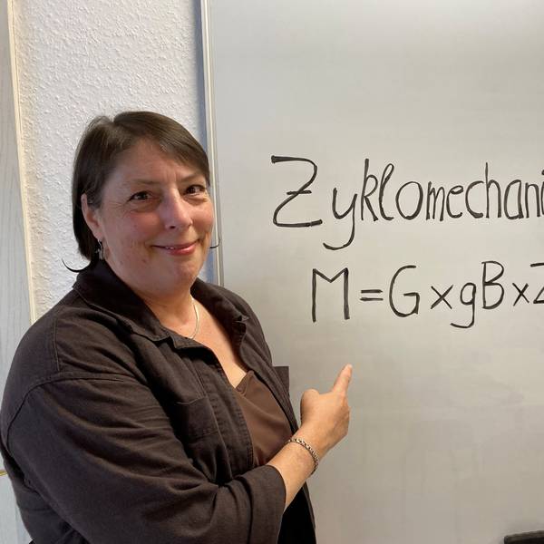 Eine Frau zeigt auf ein Plakat, auf dem steht Zyklomechanik