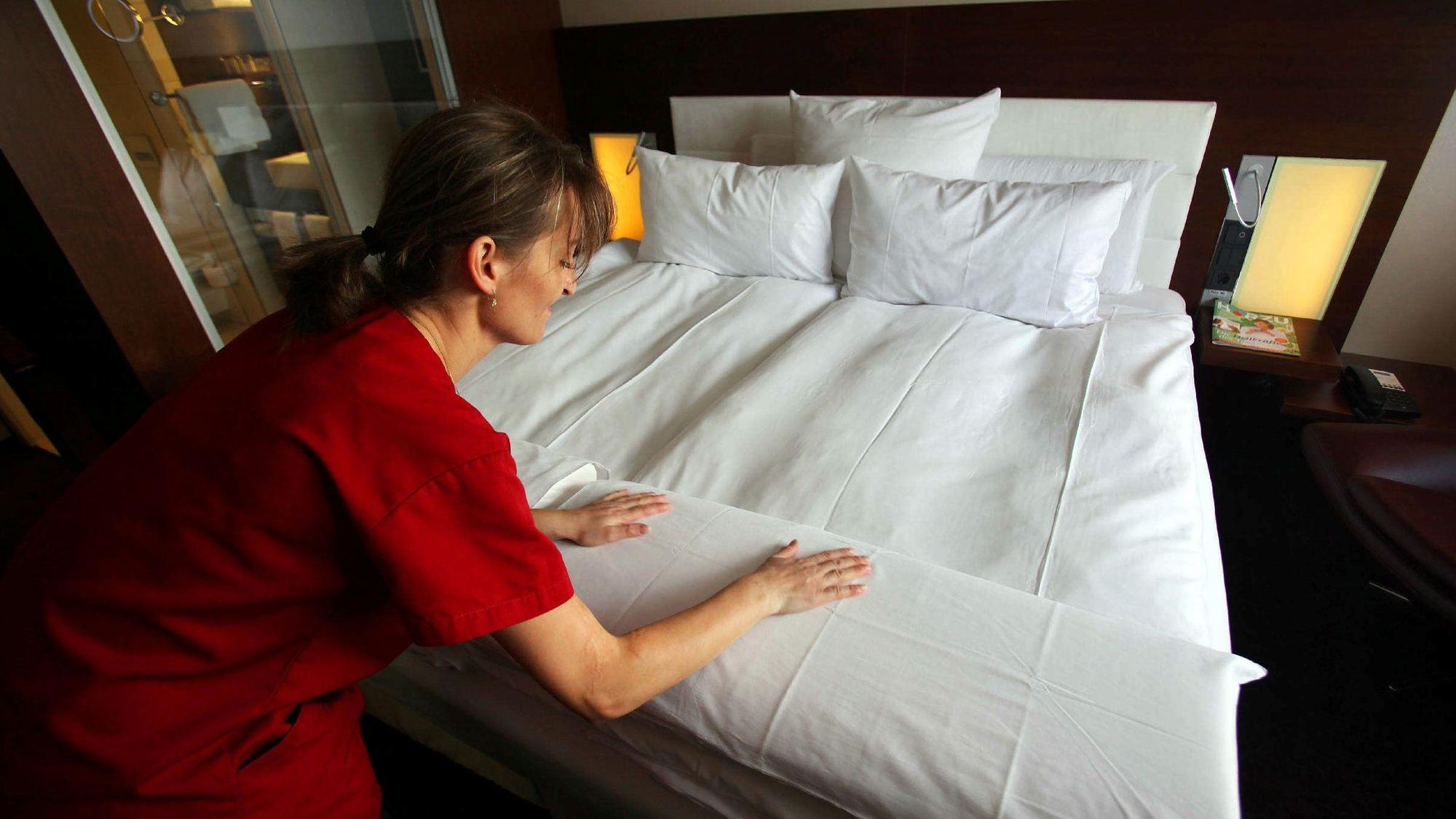 Ein Zimmermädchen macht in einem Hotel das Bett. (Symbolbild)