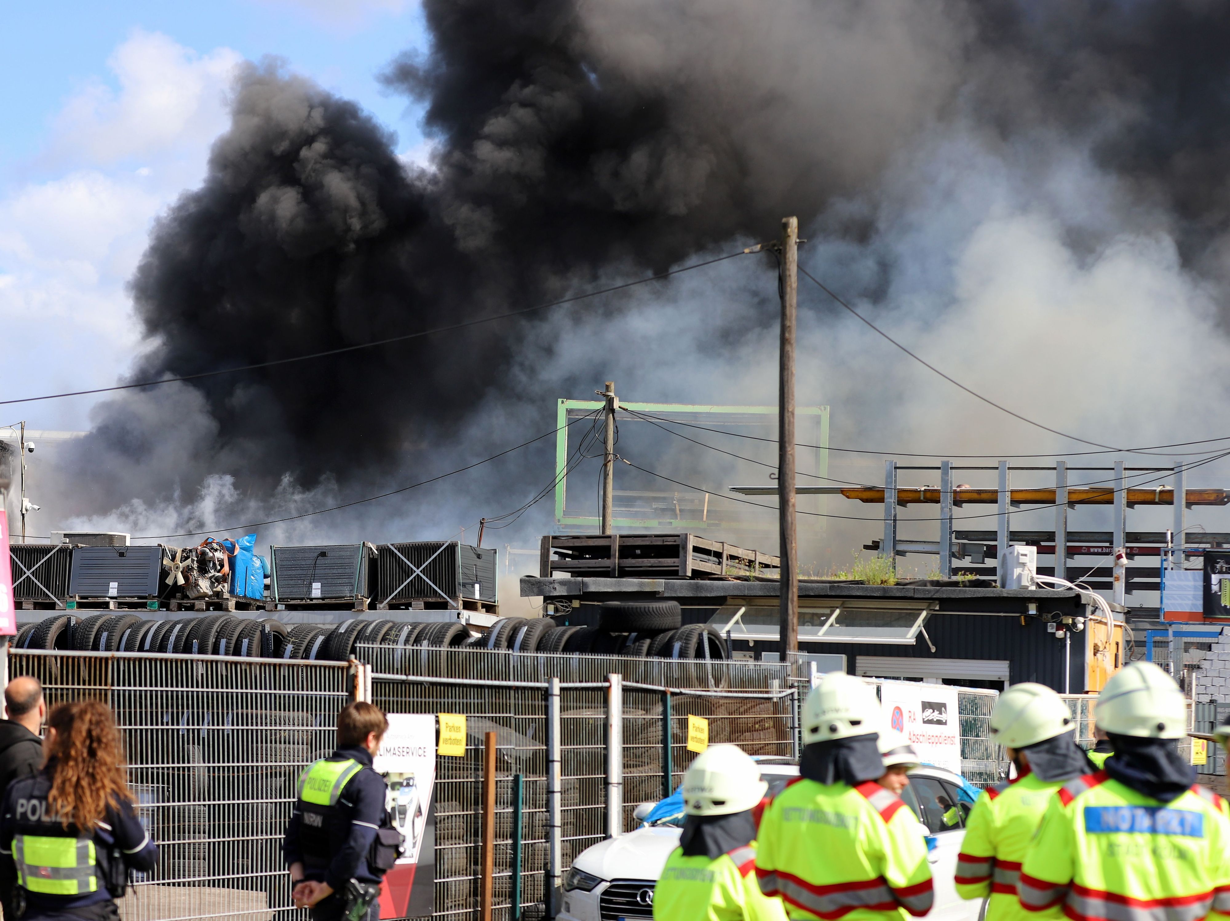 16.05.2026, Nordrhein-Westfalen, Köln: Feuerwehr und Polizei sind im Einsatz bei einem Brand in einer Werkstatt in einem alten Industrieareal - die dichte Rauchwolke ist weithin sichtbar. Foto: Sascha Thelen/dpa +++ dpa-Bildfunk +++