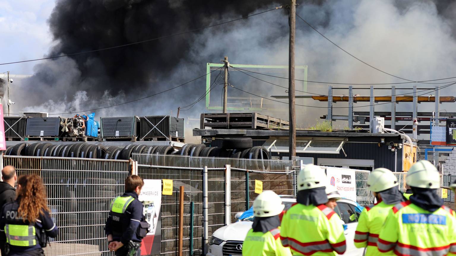 16.05.2026, Nordrhein-Westfalen, Köln: Feuerwehr und Polizei sind im Einsatz bei einem Brand in einer Werkstatt in einem alten Industrieareal - die dichte Rauchwolke ist weithin sichtbar. Foto: Sascha Thelen/dpa +++ dpa-Bildfunk +++