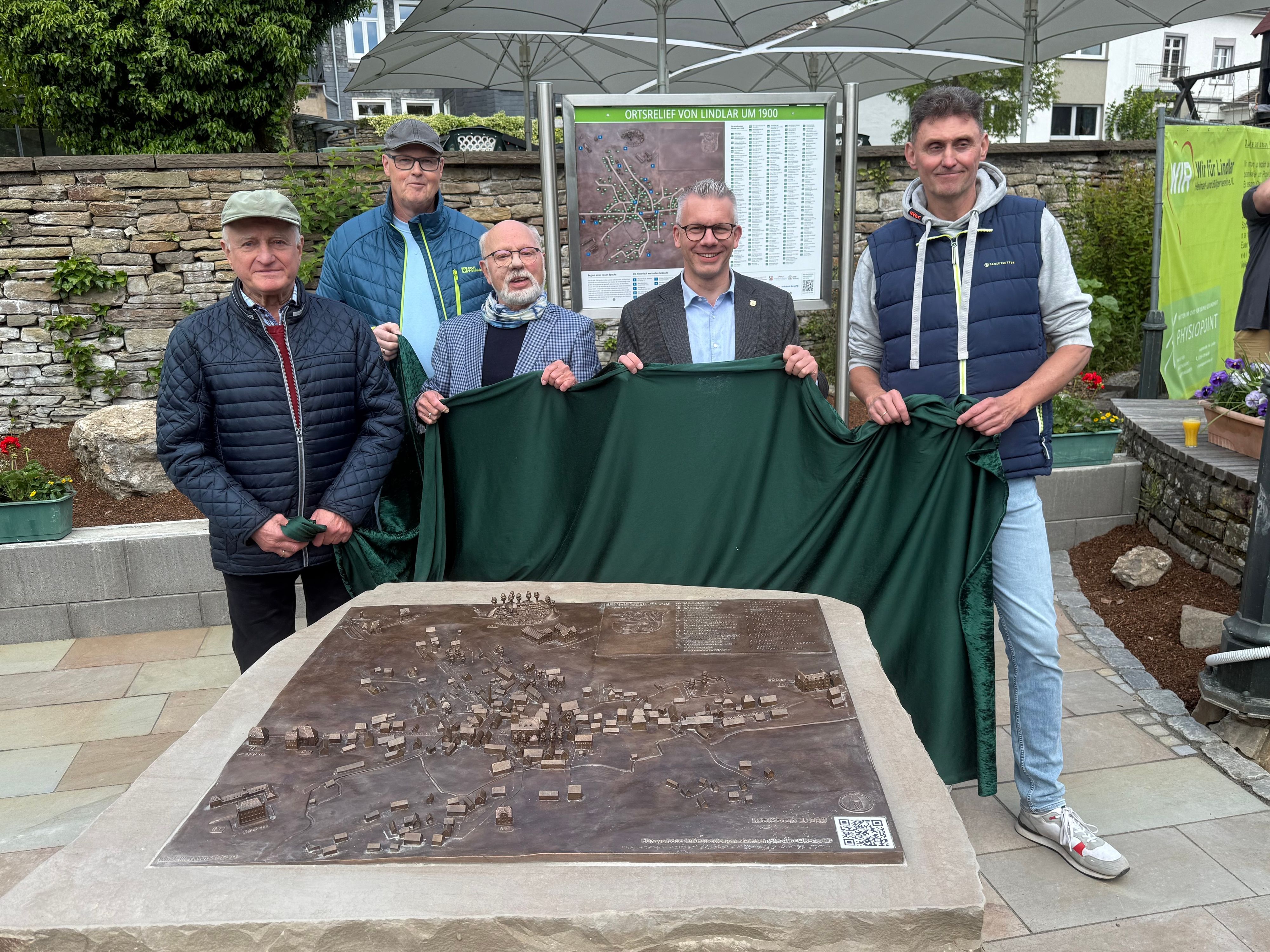 Dieses Foto zeigt (von links nach rechts) Winfried Panske, Andreas Deichsel, Burkard Graatz, Bürgermeister Sven Engelmann und Stefan Christel beim Enthüllen des Bronzereliefs.