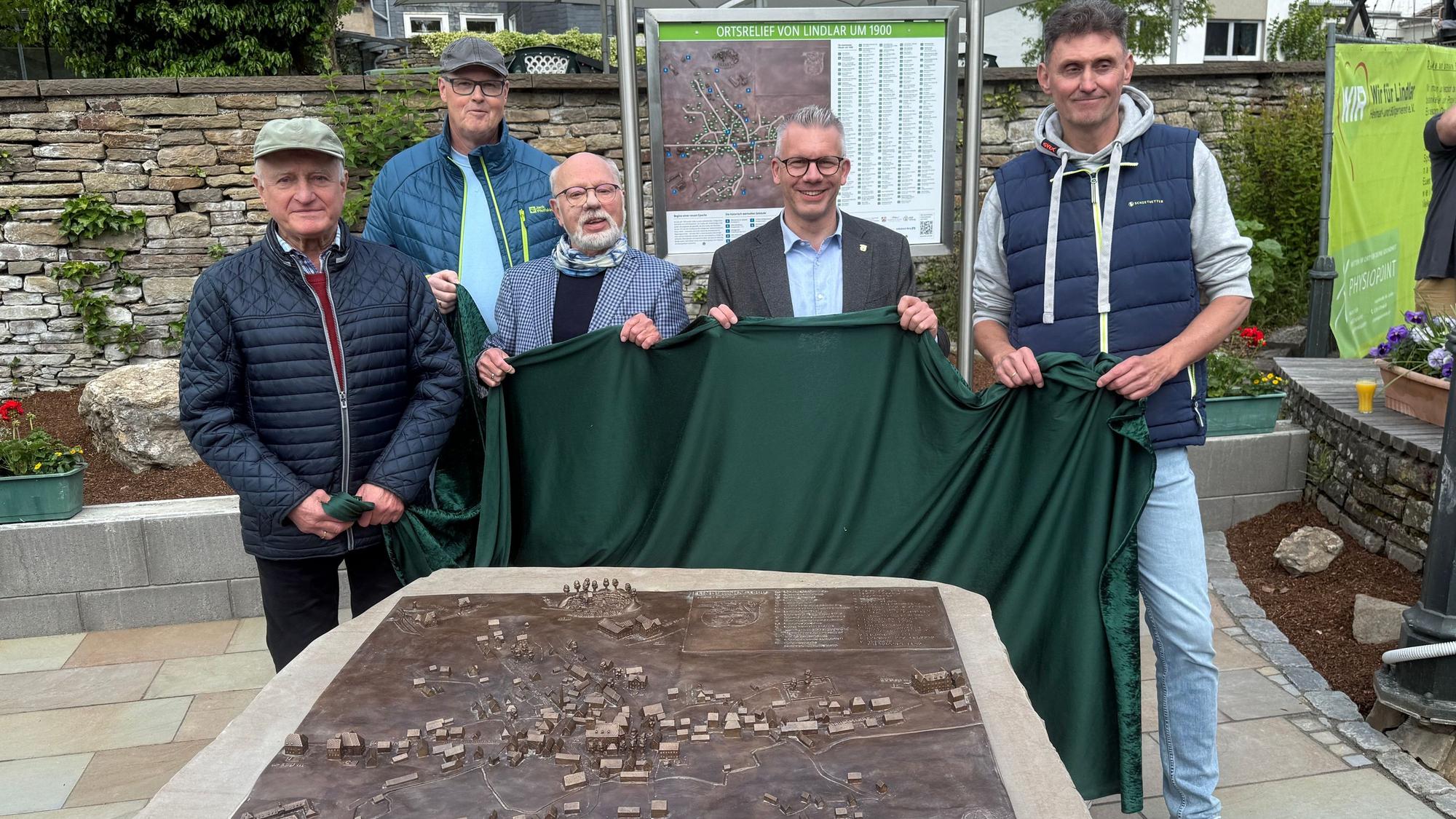 Dieses Foto zeigt (von links nach rechts) Winfried Panske, Andreas Deichsel, Burkard Graatz, Bürgermeister Sven Engelmann und Stefan Christel beim Enthüllen des Bronzereliefs.