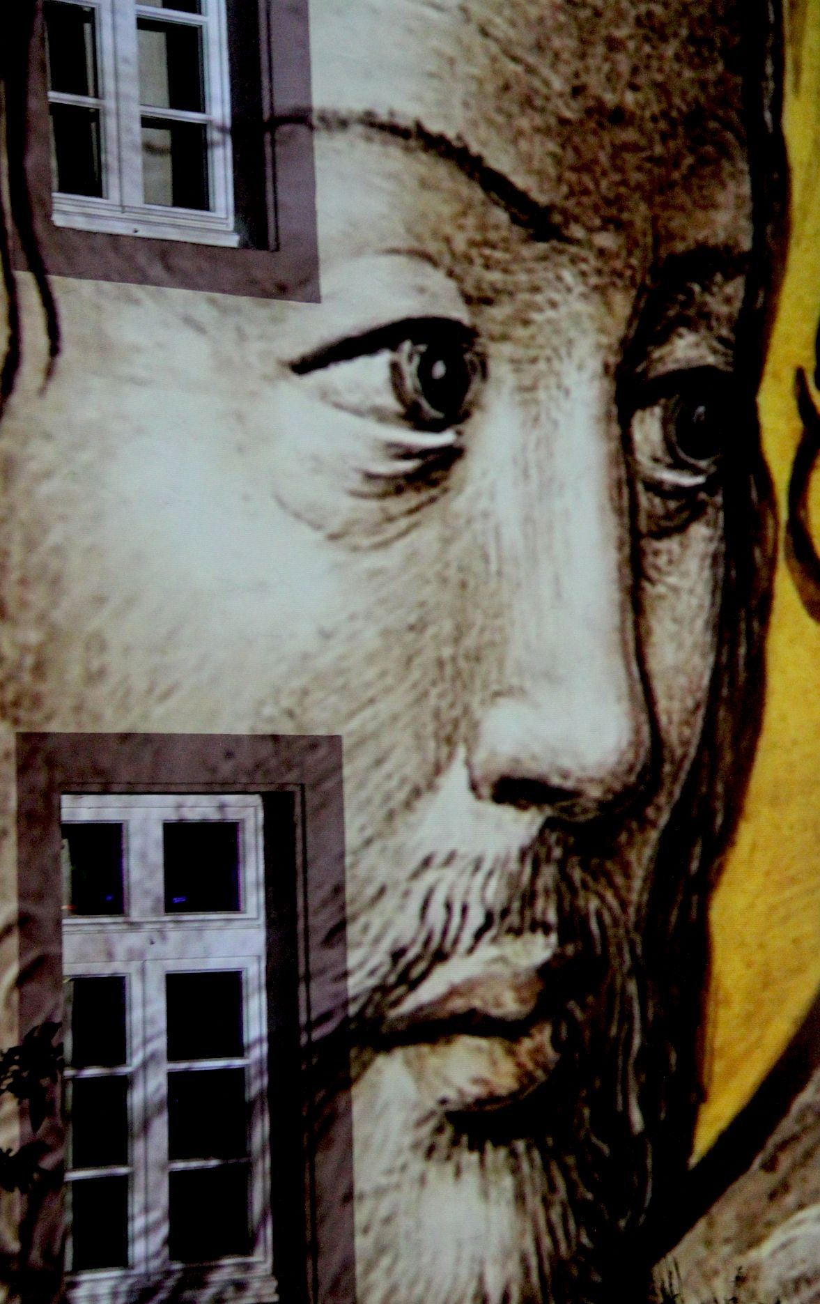 Das bärtige Gesicht eines Königs ist großformatig auf der Fassade zu sehen.