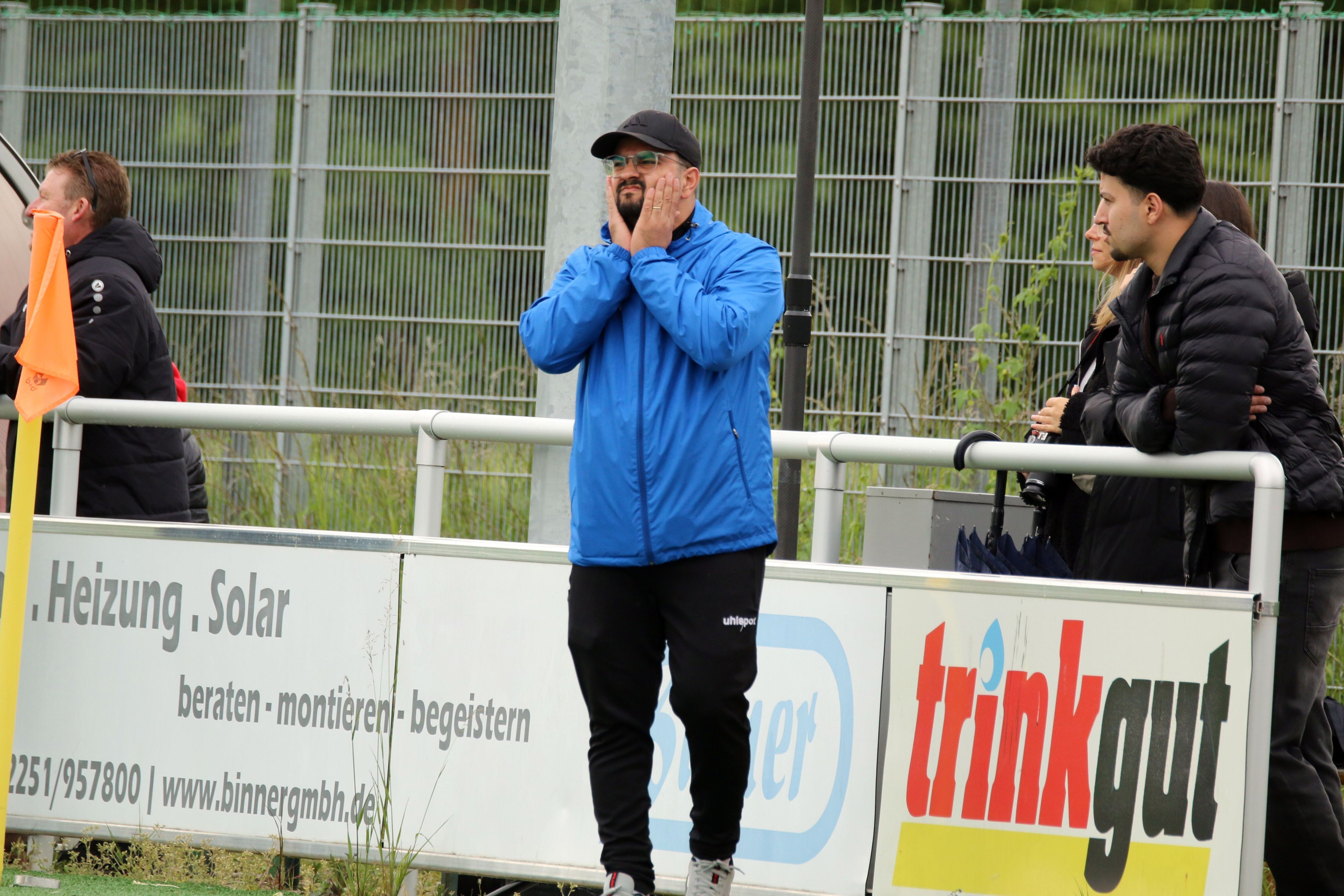 Can Celik fasst sich mit beiden Händen an die Wangen.