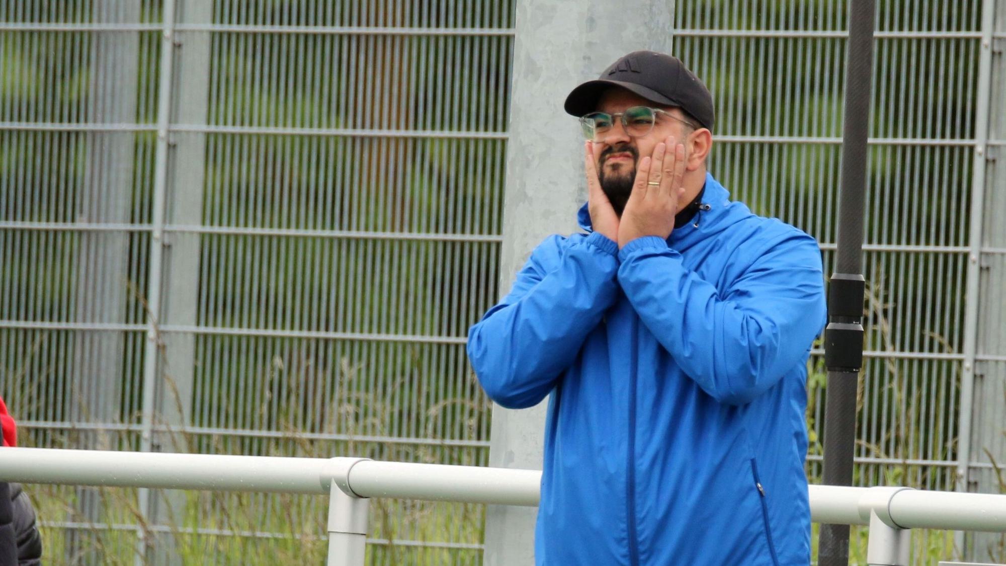 Can Celik fasst sich mit beiden Händen an die Wangen.