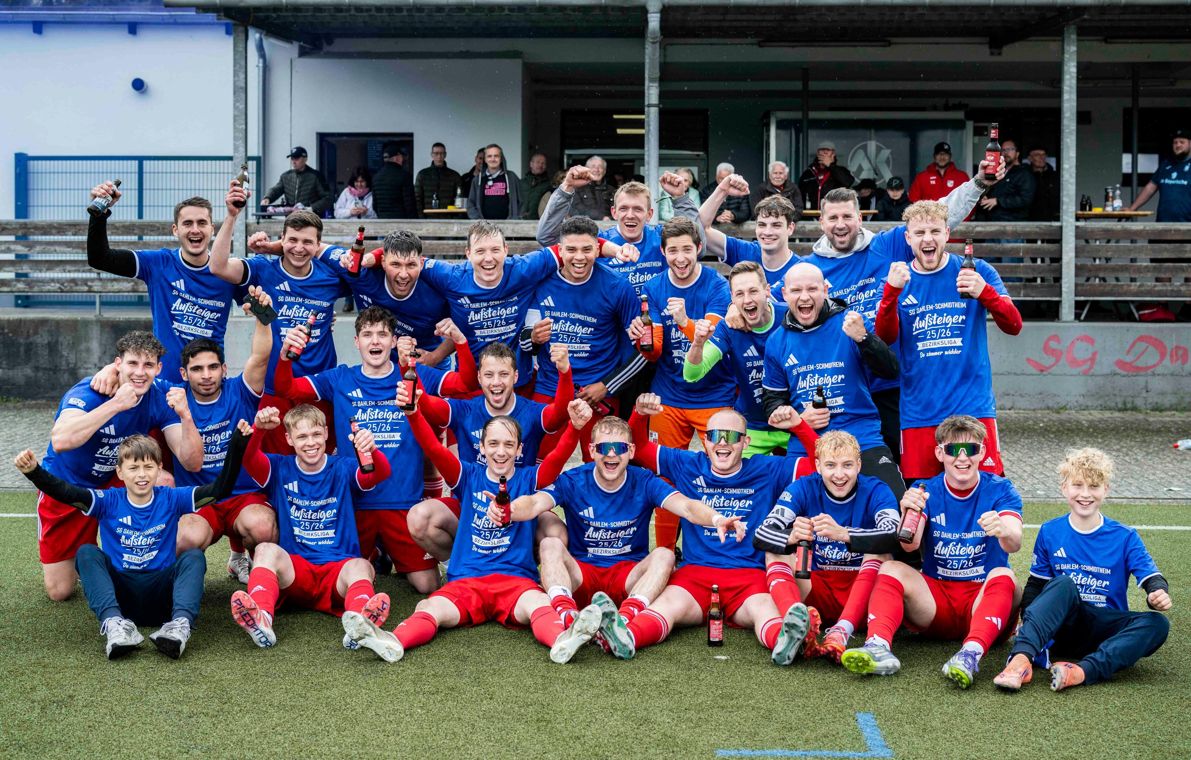 Die Spieler der SG Dahlem-Schmidtheim tragen Aufstiegs-T-Shirts und versammeln sich zum offiziellen Aufstiegsfoto.