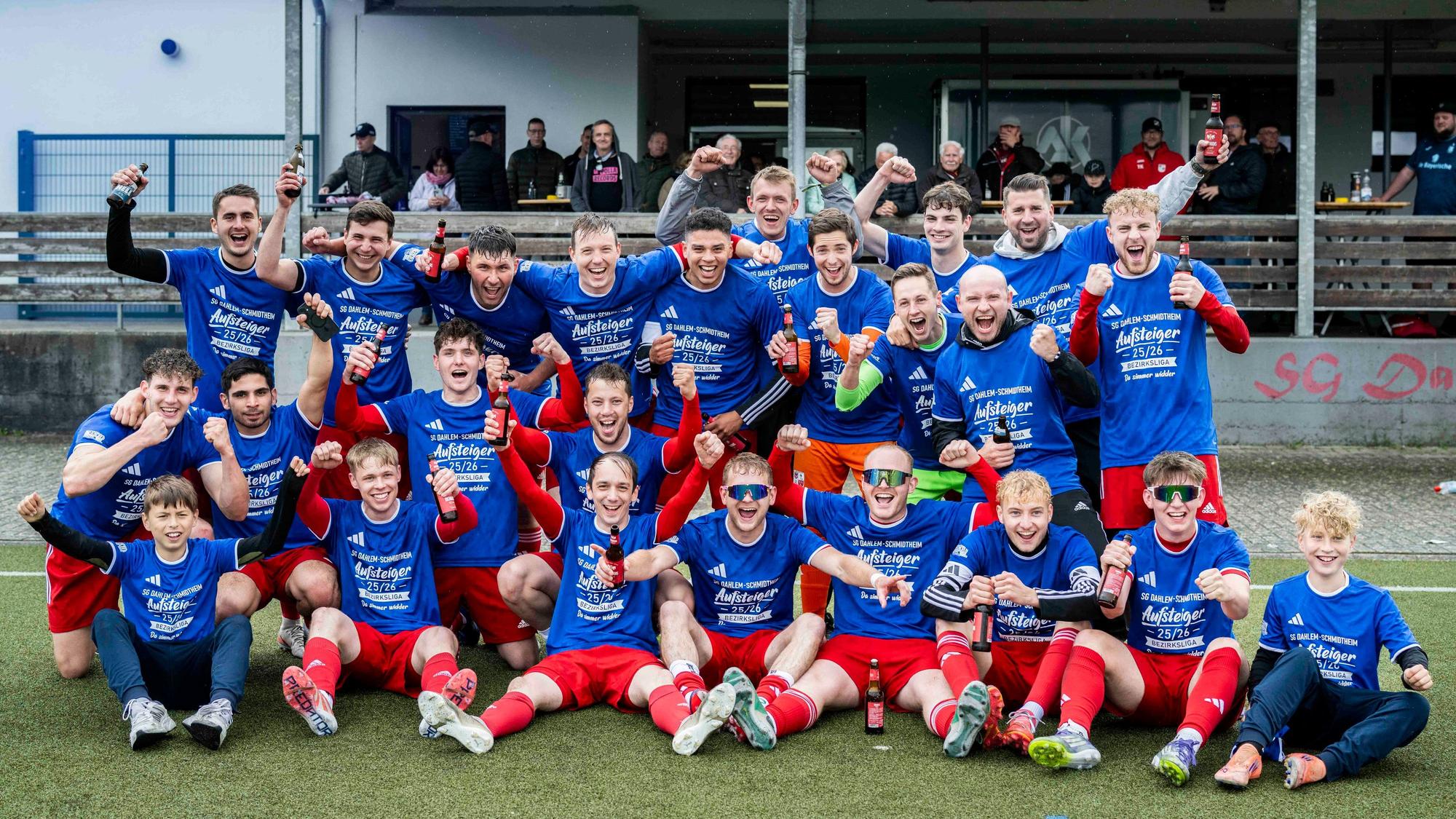 Die Spieler der SG Dahlem-Schmidtheim tragen Aufstiegs-T-Shirts und versammeln sich zum offiziellen Aufstiegsfoto.