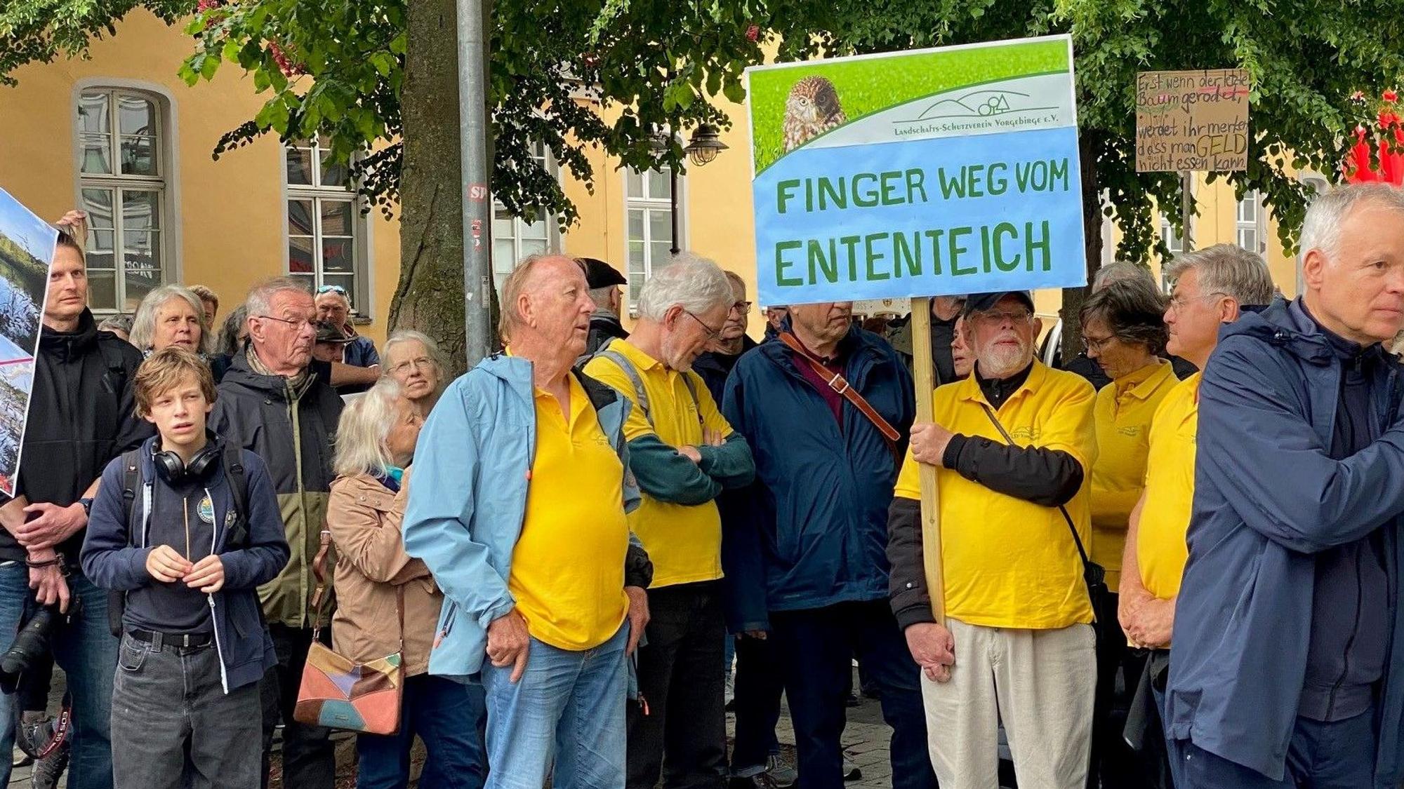 Zu sehen sind Demonstranten, sie halten Schilder hoch.