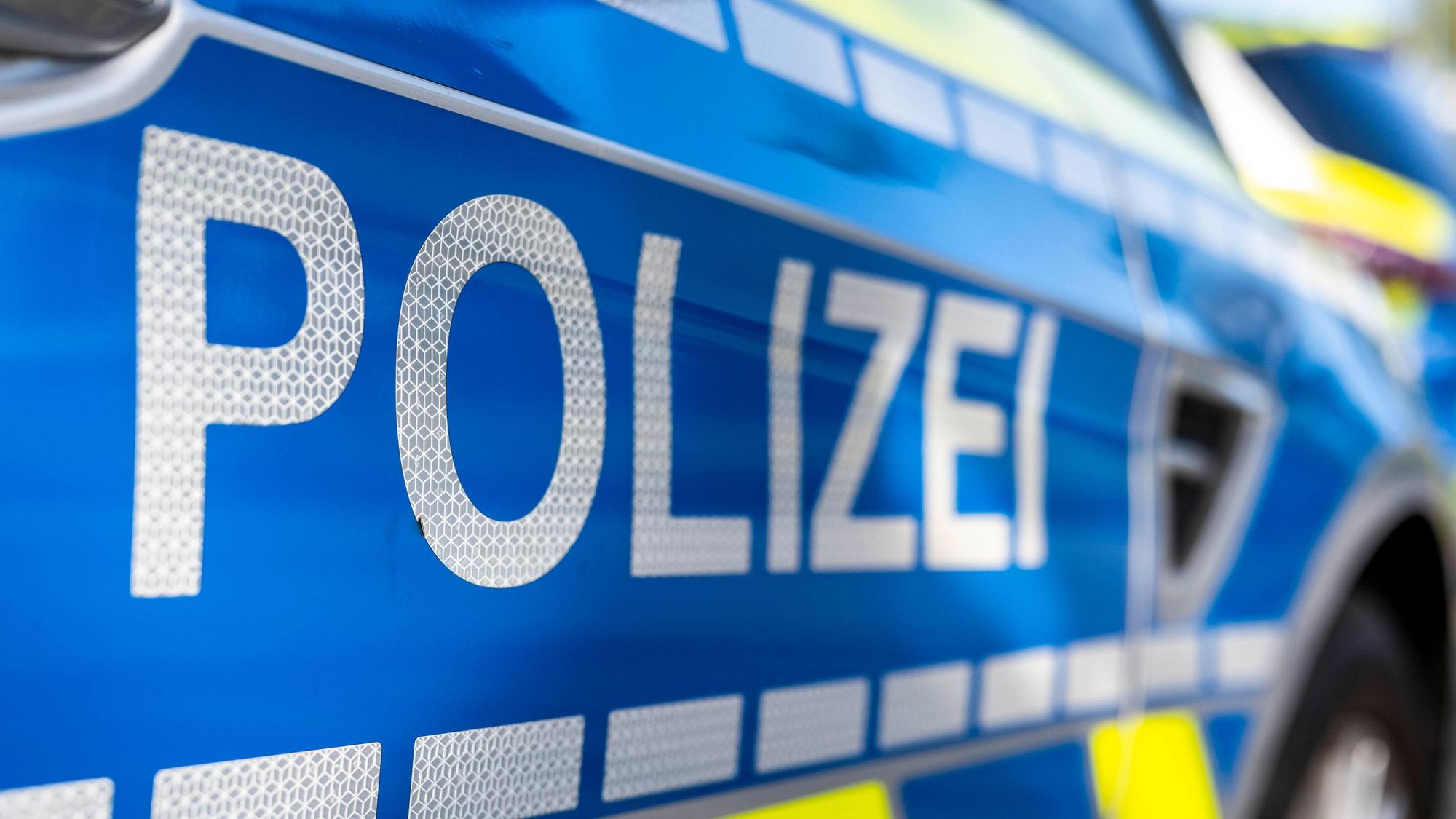 An der Tür von einem Streifenwagen steht der Schriftzug „Polizei“