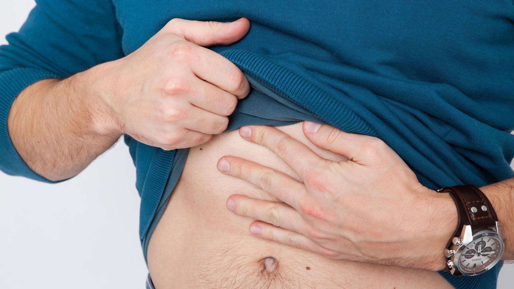 Mann fasst sich an den Bauch