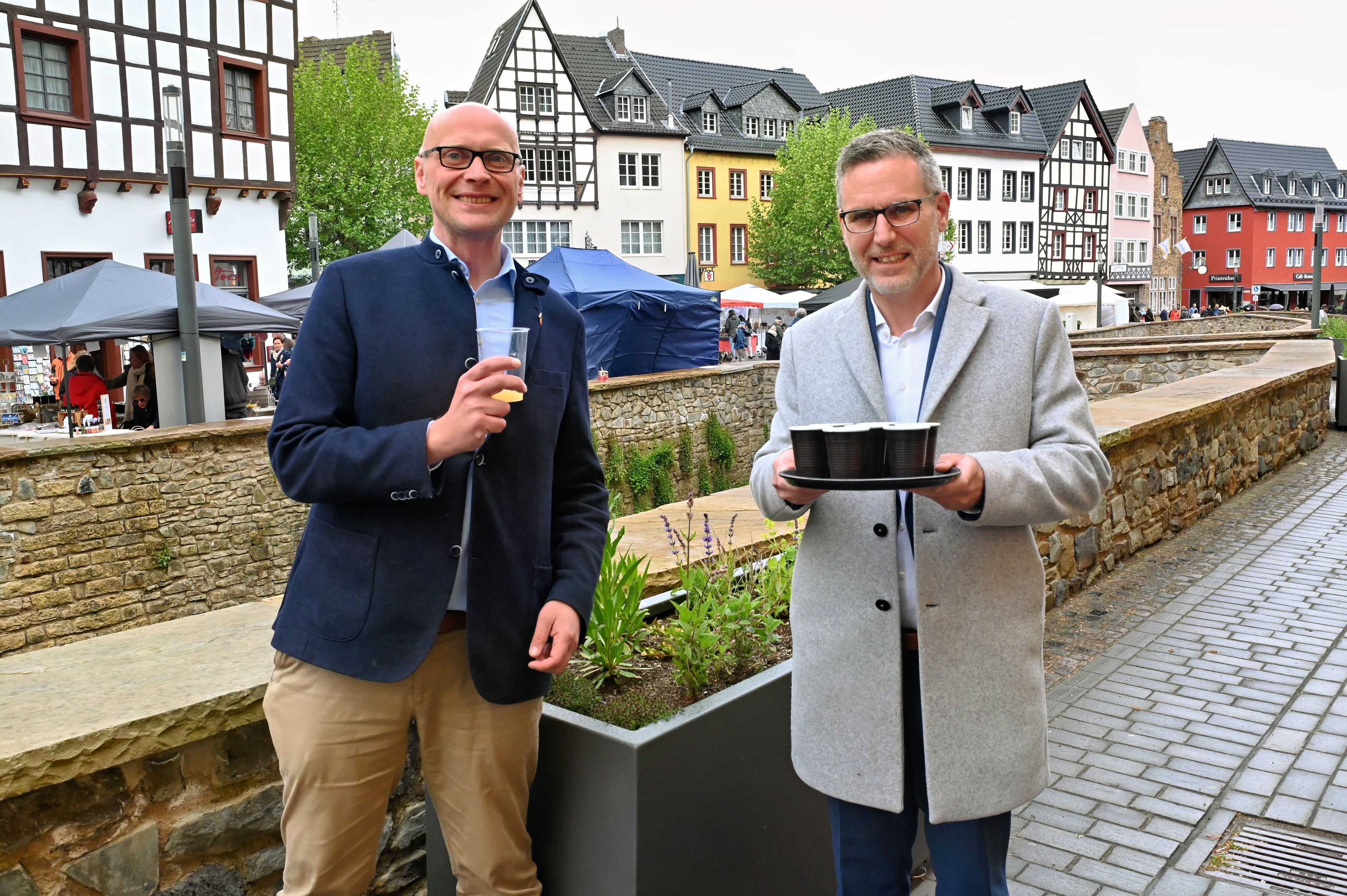 Norbert Crump hält Kräutergetränke in der Hand, sein Amtskollege Sebastian Glatzel hat schon probiert.