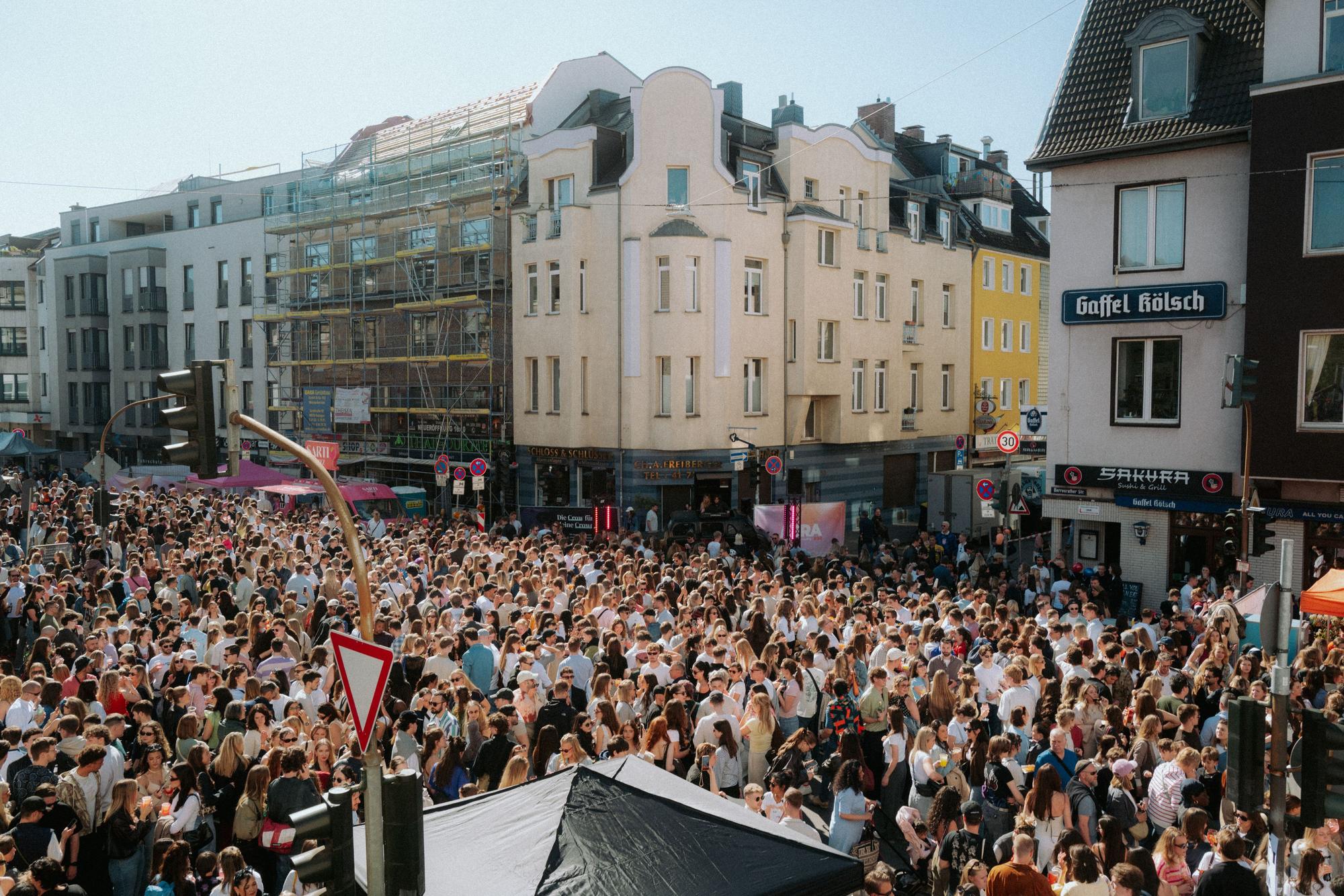 Eine Straßenkreuzung ist pickepacke voll mit Menschen.