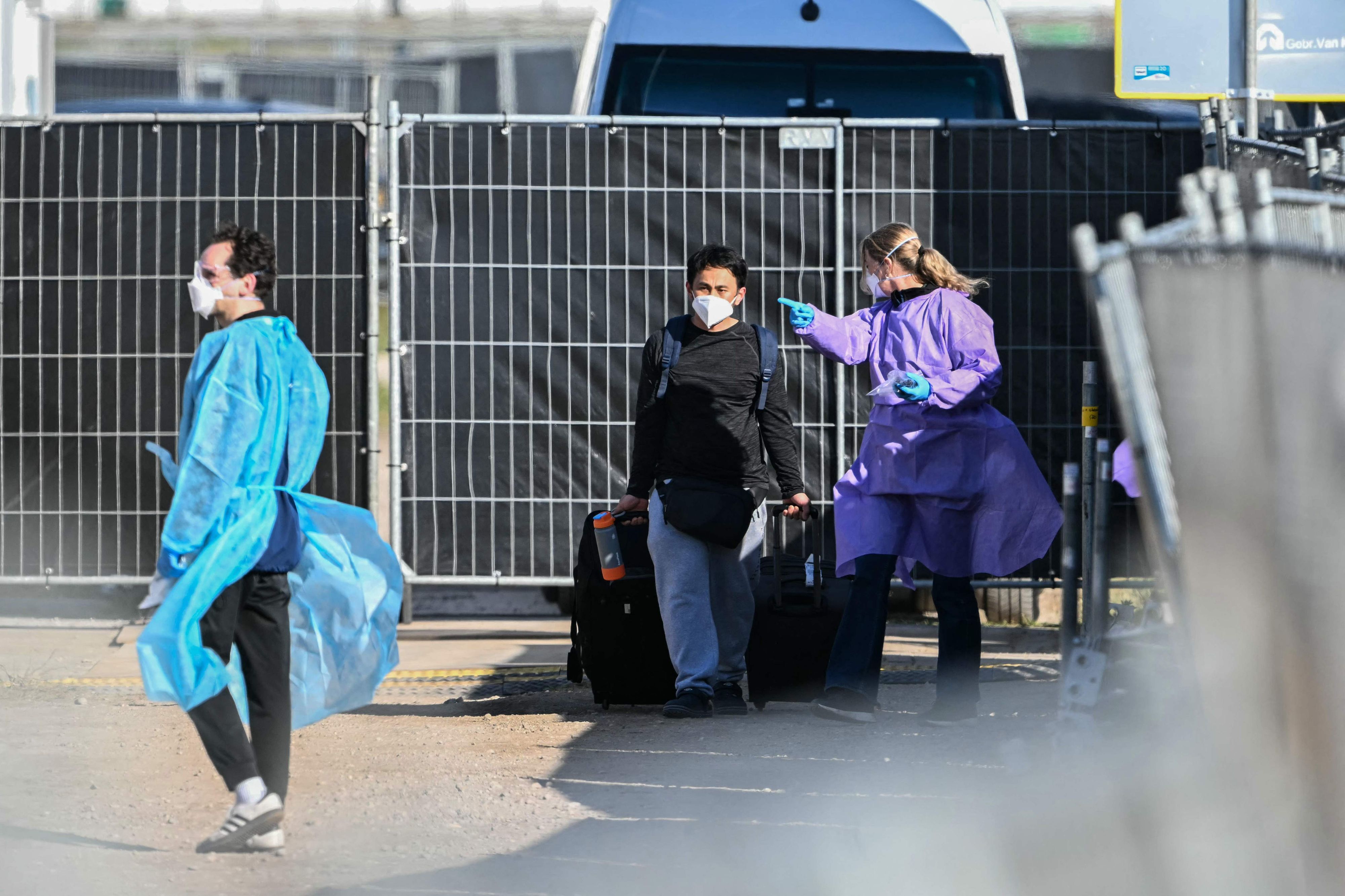 Ein Mann mit Atemschutzmaske verlässt in Begleitung von medizinischem Personal das von einem Hantavirus-Ausbruch betroffene niederländische Kreuzfahrtschiff „Hondius“ im Hafen von Rotterdam.