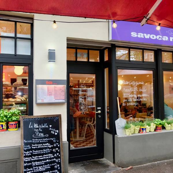 Unter einer roten Markise ist der Eingang zum Restaurant Savoca Mercato.