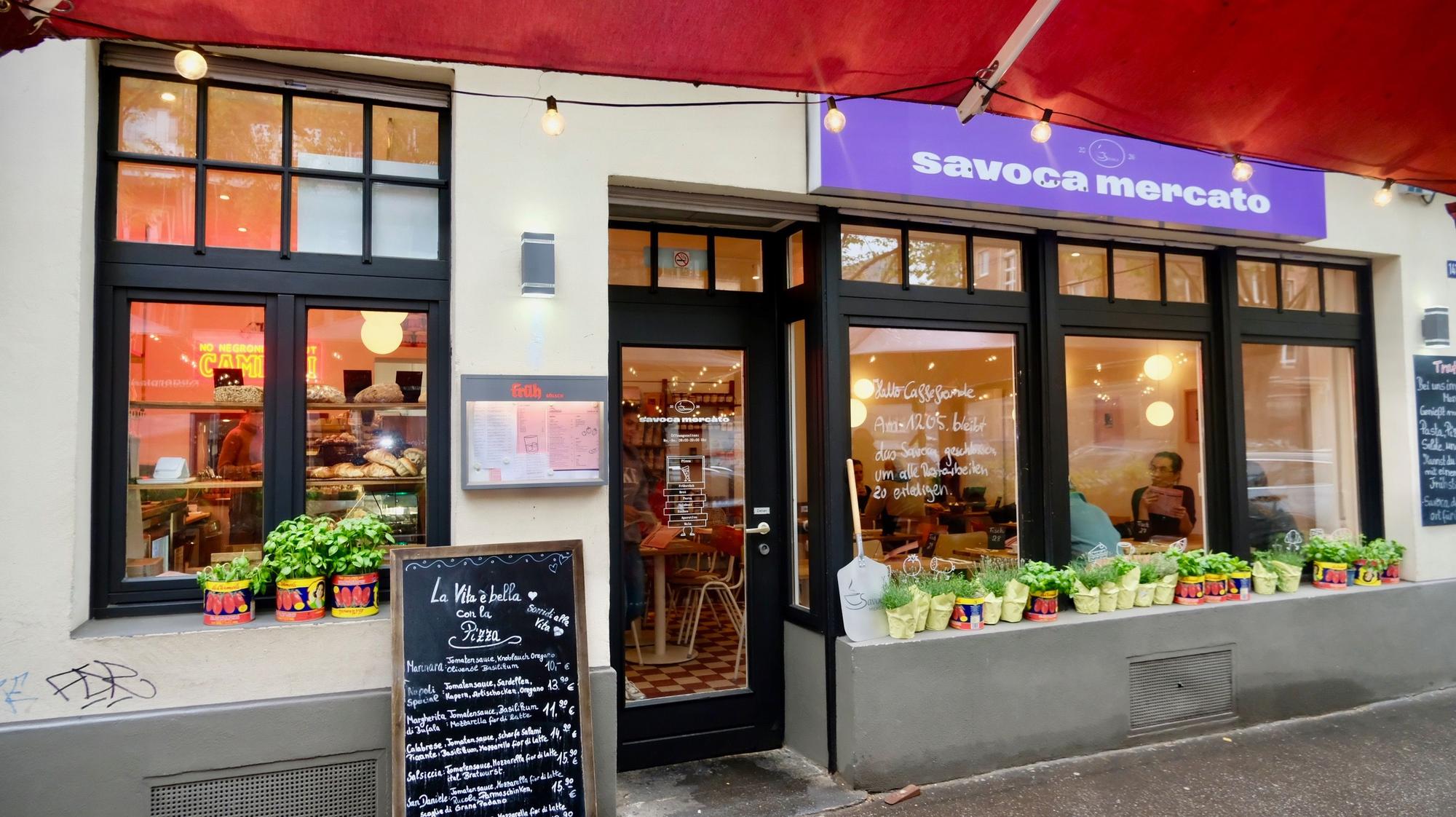 Unter einer roten Markise ist der Eingang zum Restaurant Savoca Mercato.
