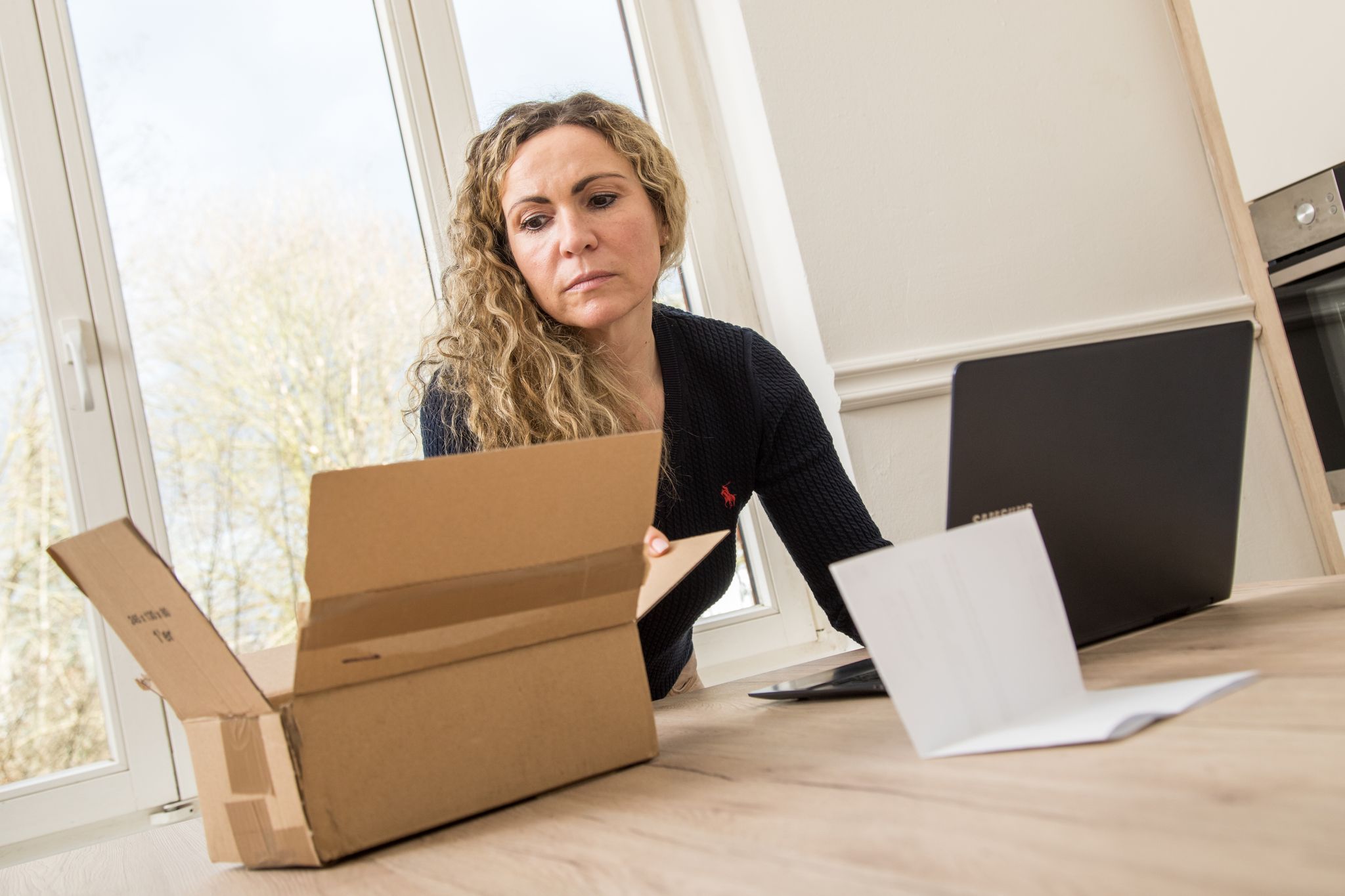 Frau schaut in den Karton einer Online-Lieferung