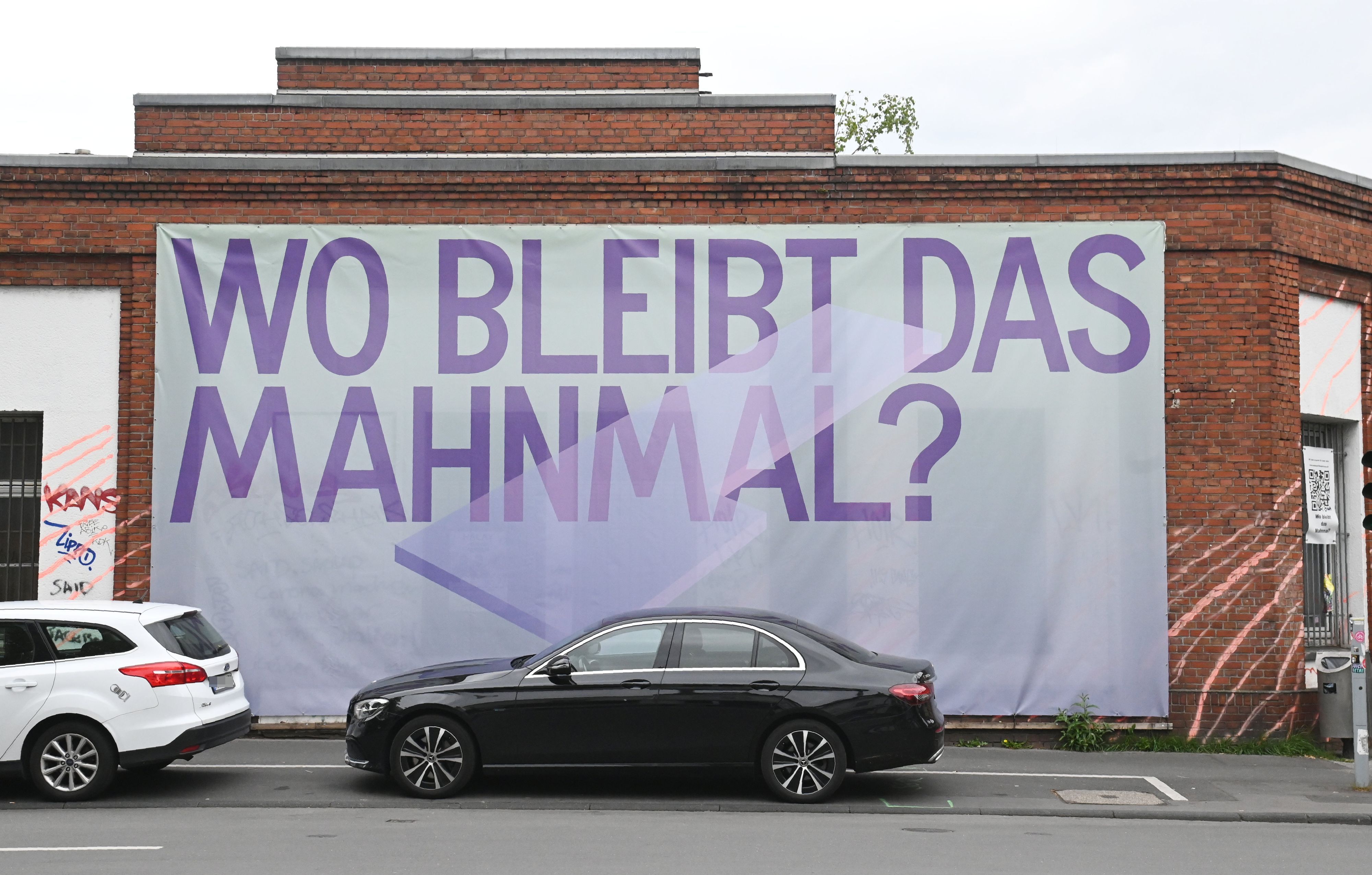19.05.2026 Köln. An der Keupstraße hängt ein Transparent „Wo bleibt das Mahnmal?“. Es soll auf das bislang nicht realisierte Denkmal zum Anschlag des NSU in der Keupstraße im Jahr 2004 hinweisen. Foto: Alexander Schwaiger