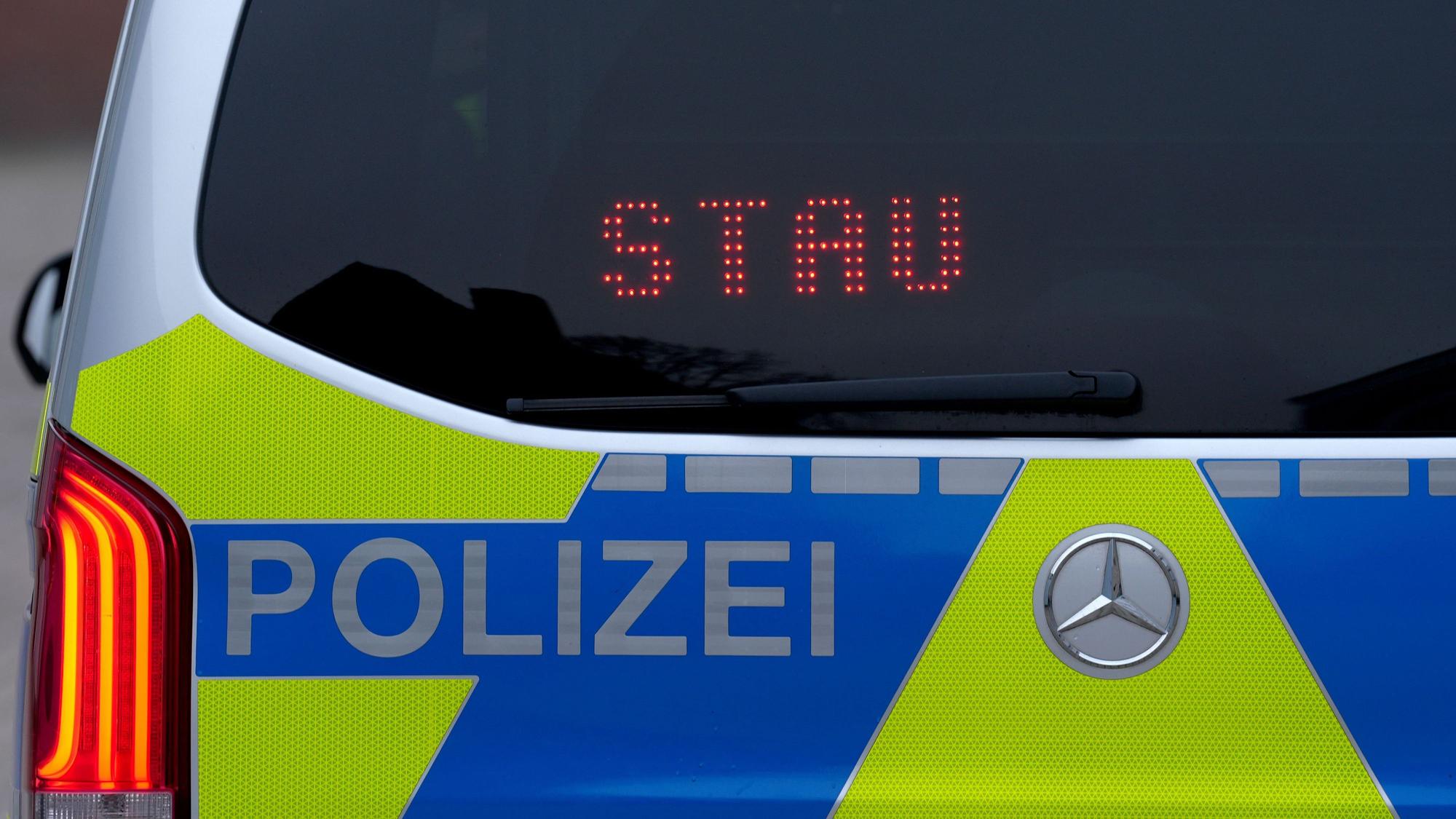 Der Schriftzug „Stau“ ist auf der Heckscheibe eines Polizeifahrzeugs zu lesen.