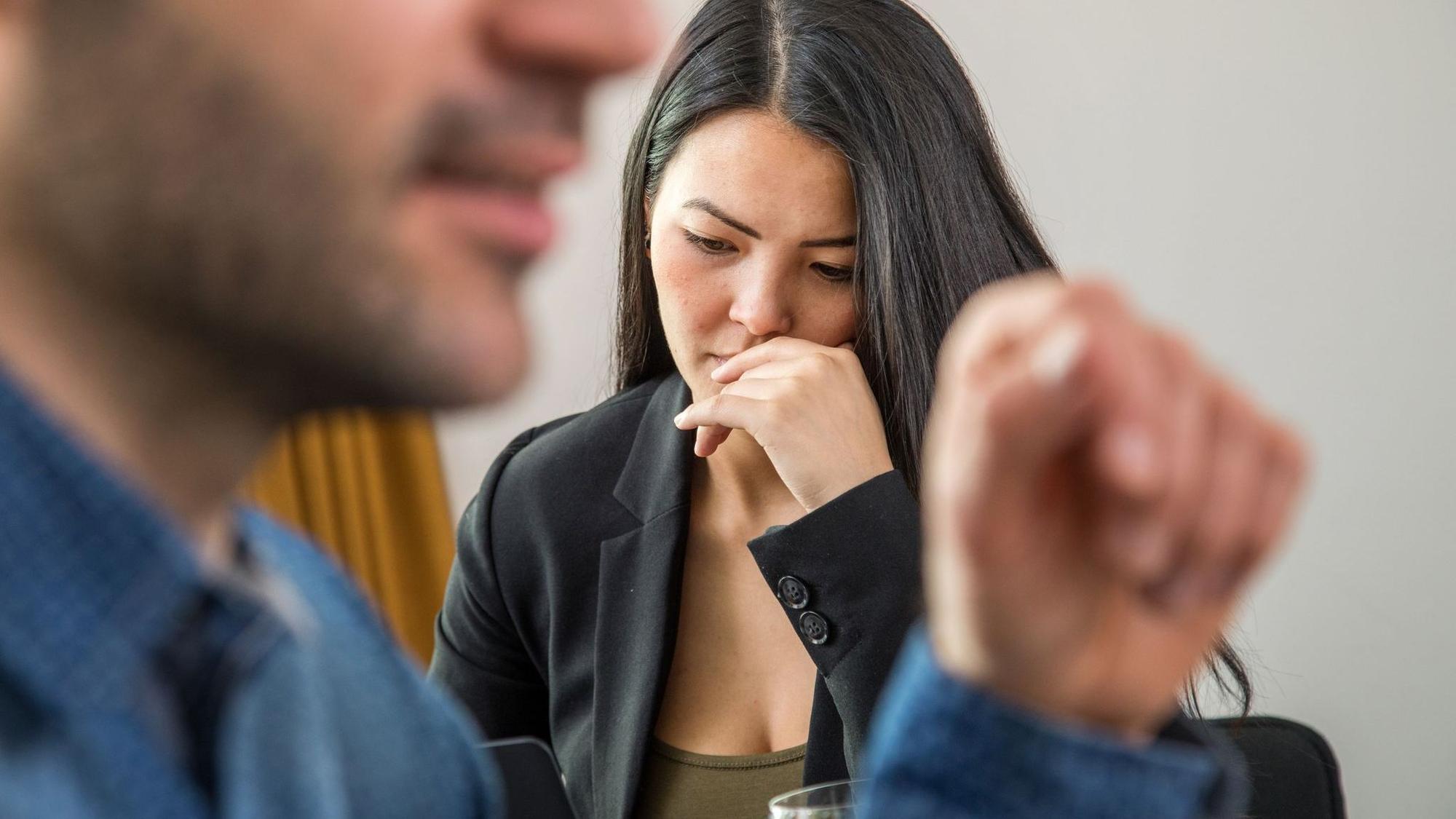 Frau schaut niedergeschlagen während eines Gesprächs