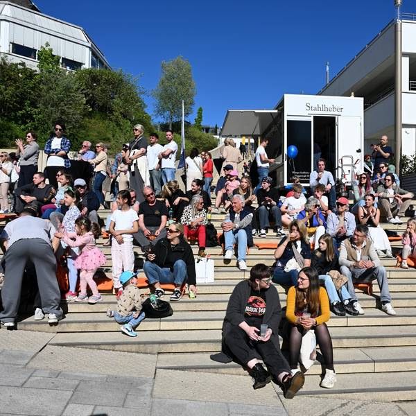 Menschen sitzen auf einer Treppe.