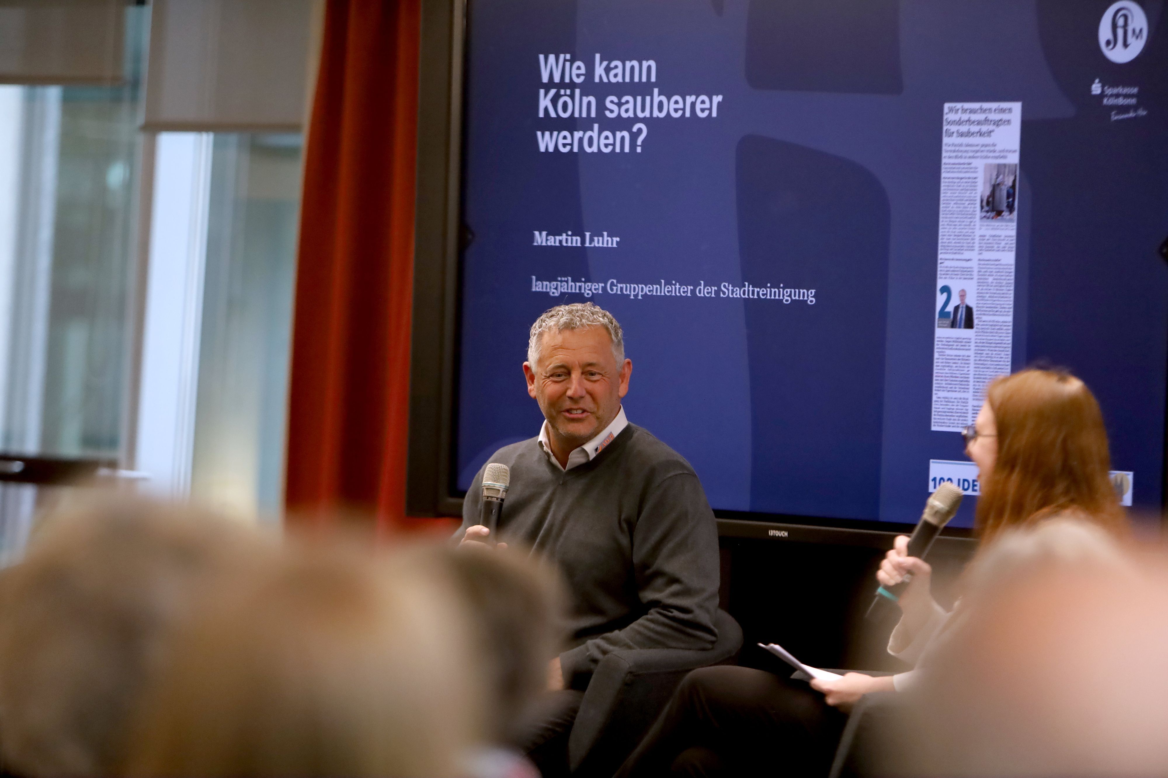 Martin Luhr, langjähriger Gruppenleiter der Kölner AWB, mit Kommunal-Reporterin Julia Hahn-Klose auf der Bühne.