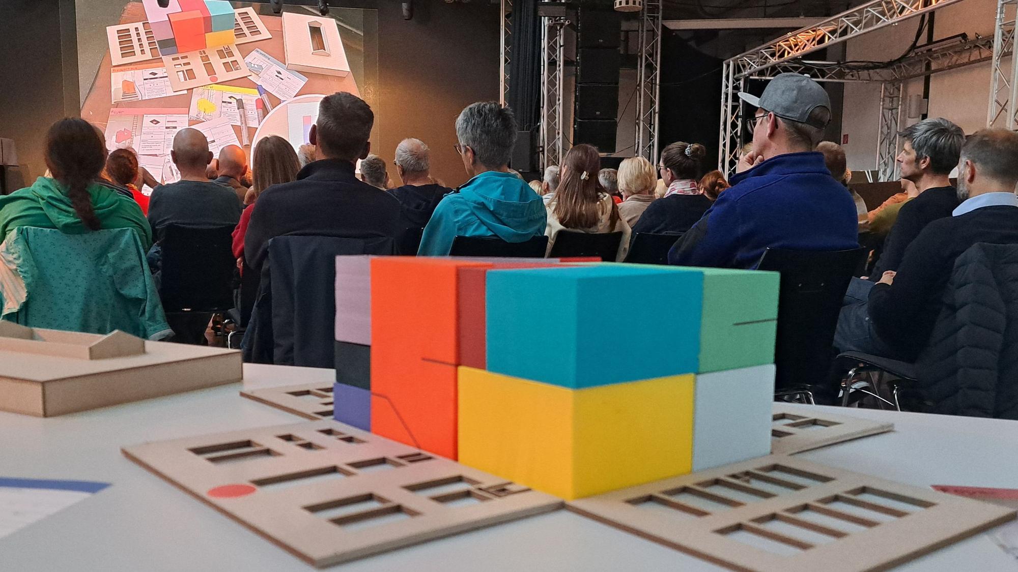 Das Foto zeigt viele Besucher der Inforveranstaltung und ein Modell des Radium-Turbinenhauses im Vordergrund.