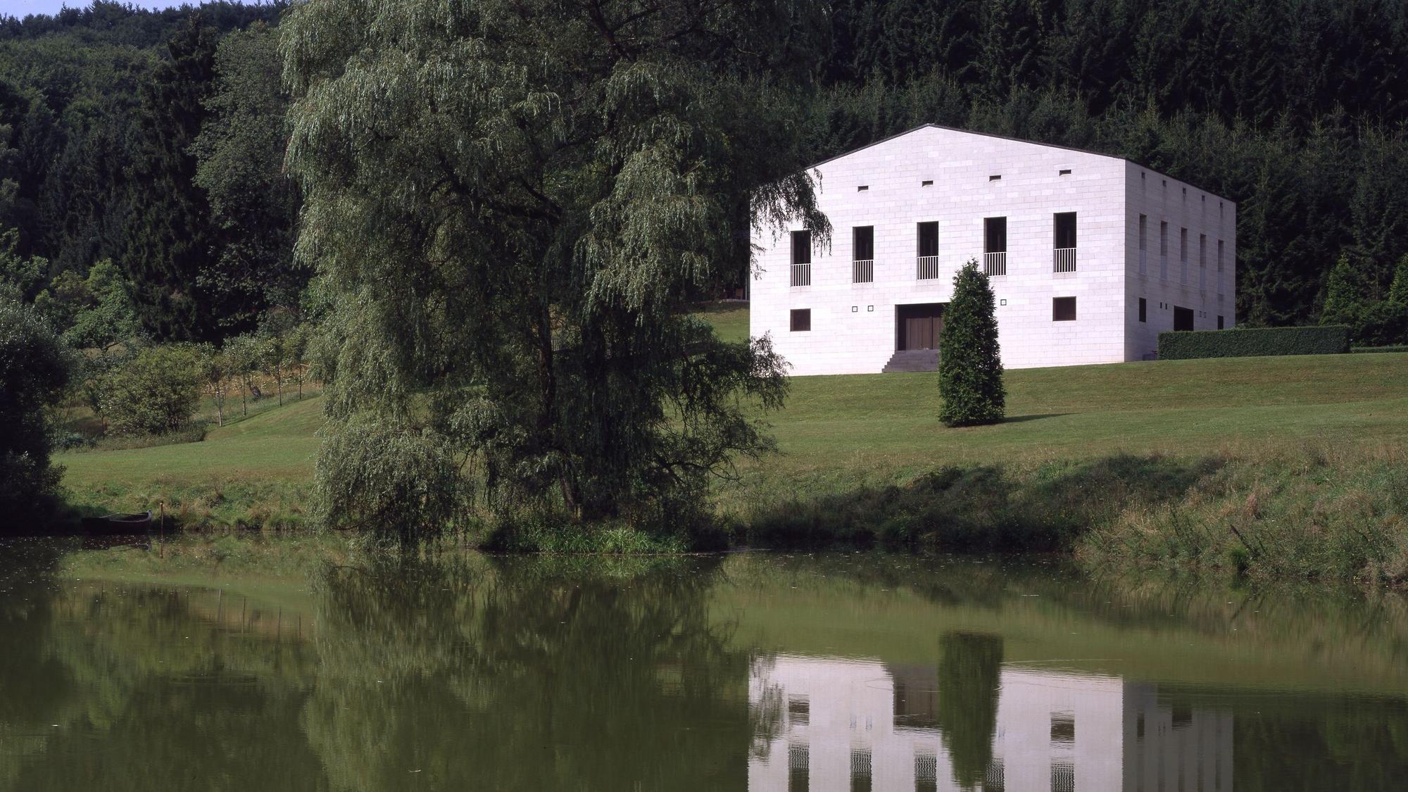 Ein Haus spiegelt sich in einem Teich.
