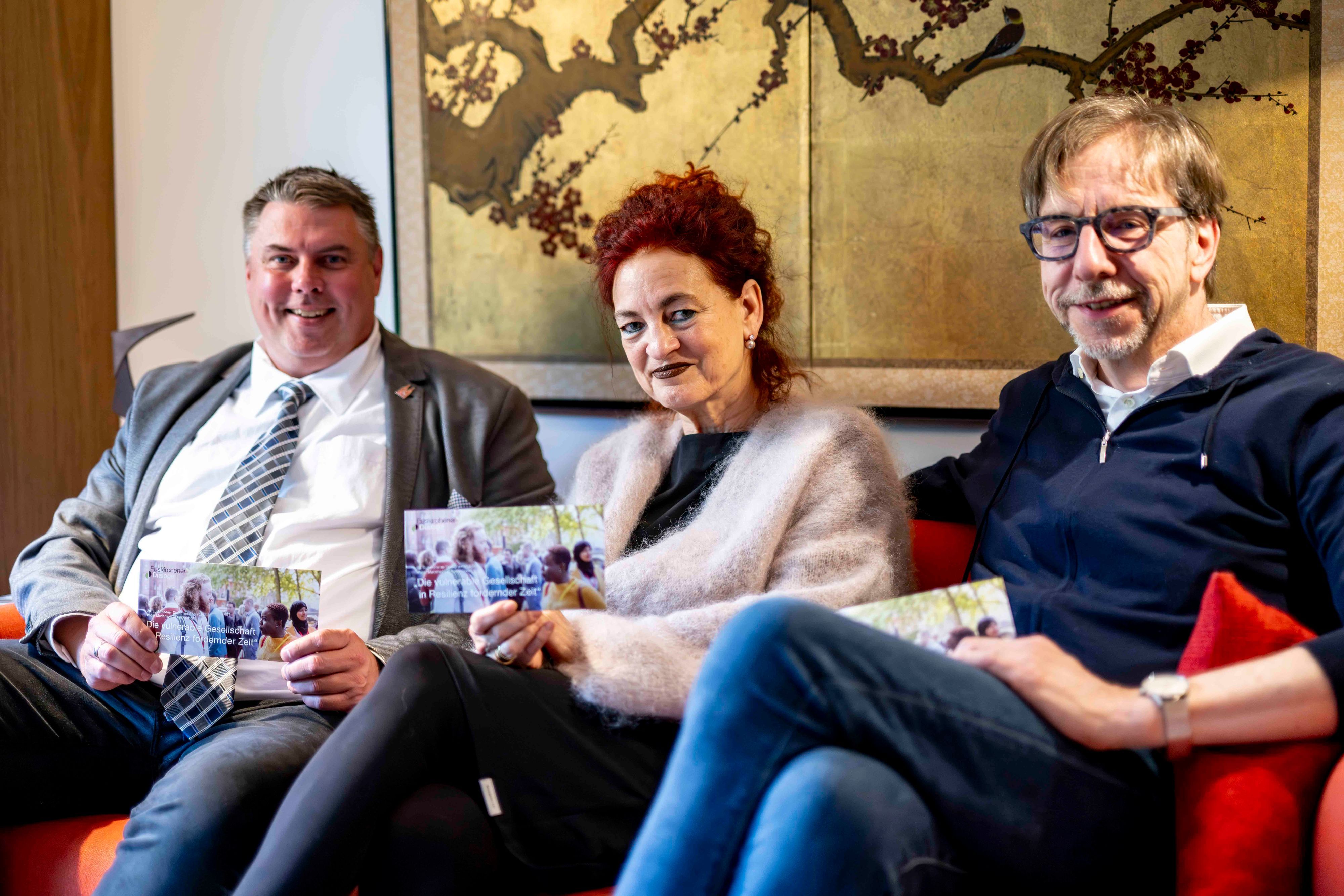Michael Mombaur (l.), Dr. Ulrike Bardt und Dr. Hubertus Rüber sitzen auf einem Sofa.