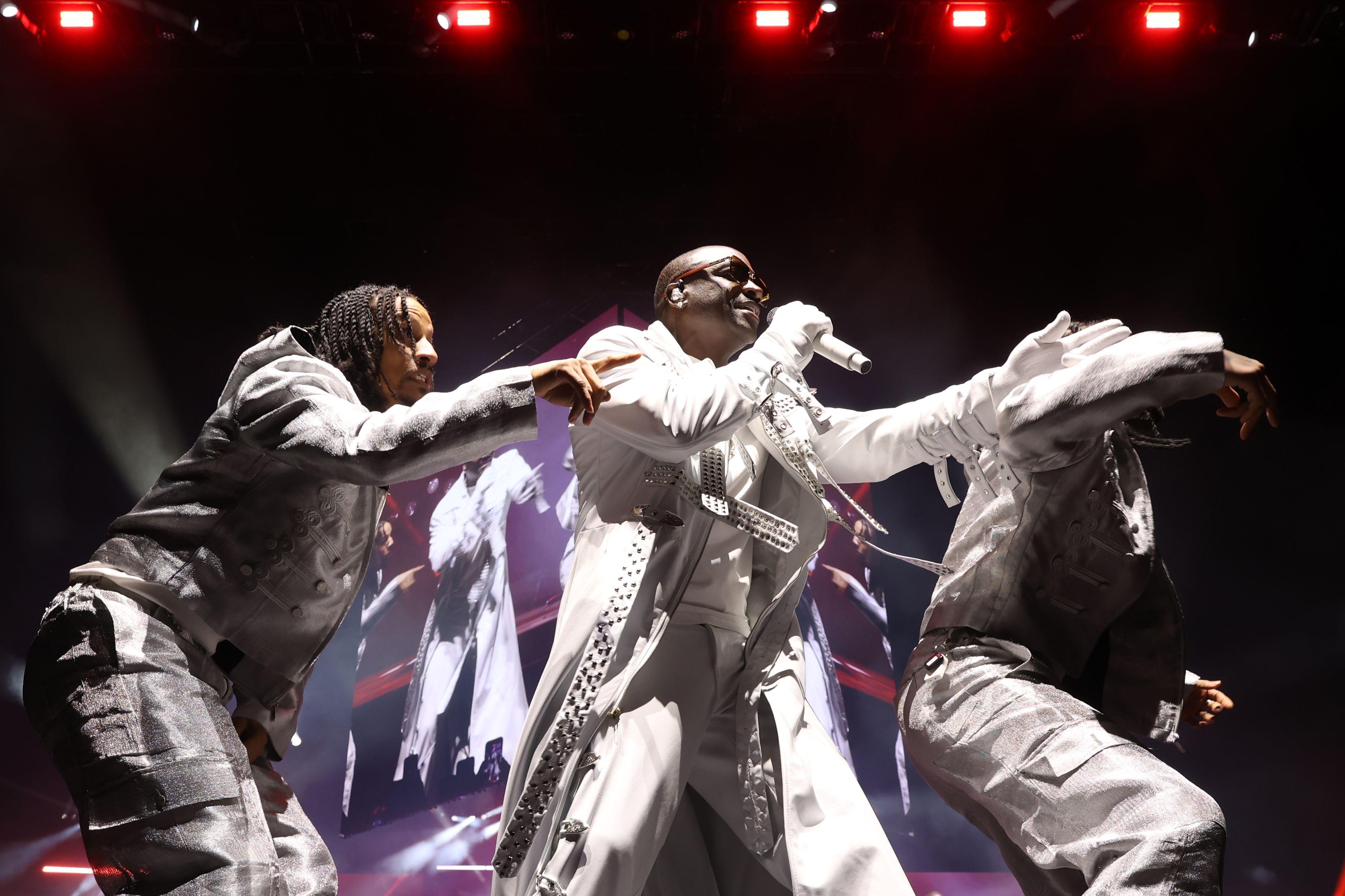 Akon im weißen Anzug mit zwei seiner Tänzer
