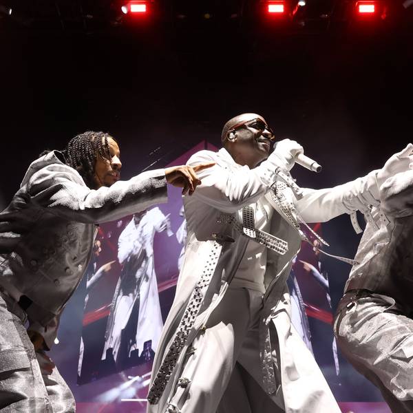 Akon im weißen Anzug mit zwei seiner Tänzer