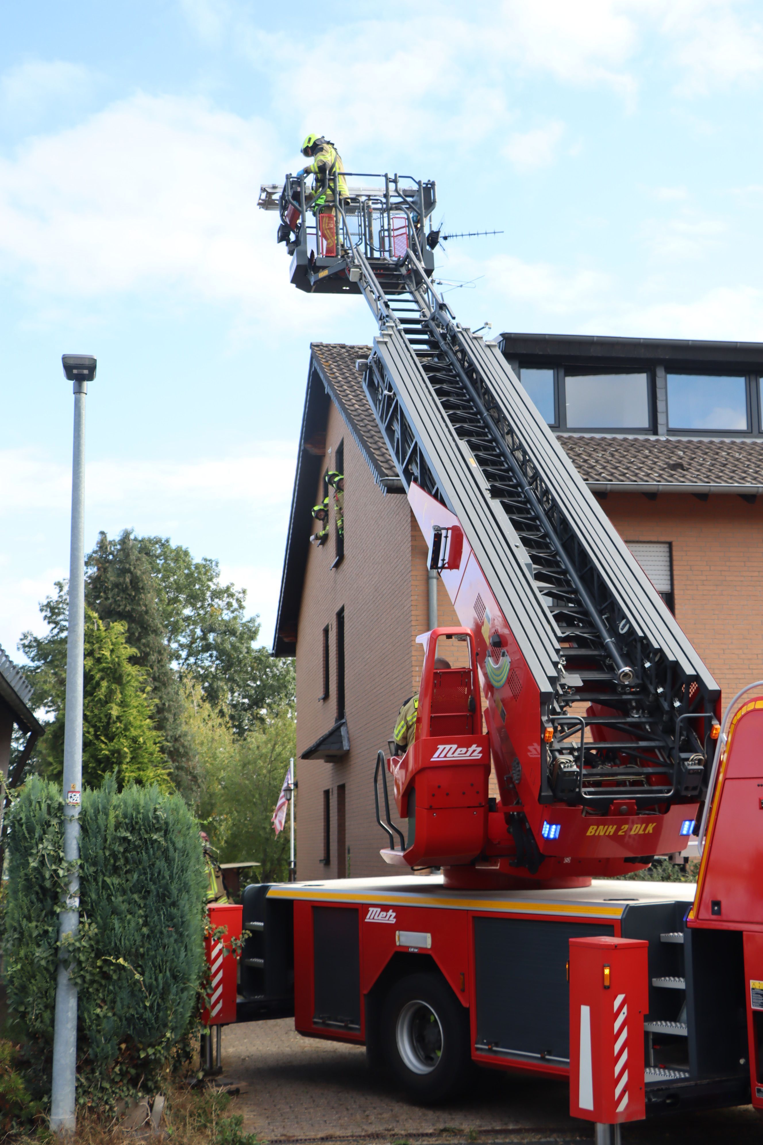 Für den Transport des verletzten aus dem Flurfenster des Obergeschosses wird die Drehleiter in Stellung gebracht.