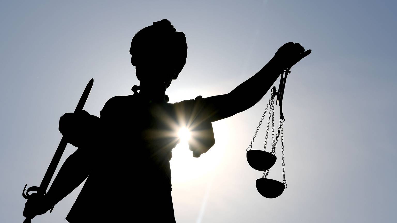 Die Göttin Justitia im Gegenlicht auf dem Gerechtigkeitsbrunnen in Frankfurt am Main.