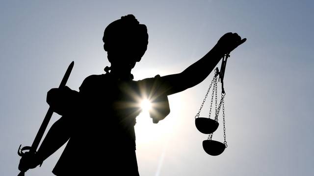 Die Göttin Justitia im Gegenlicht auf dem Gerechtigkeitsbrunnen in Frankfurt am Main.