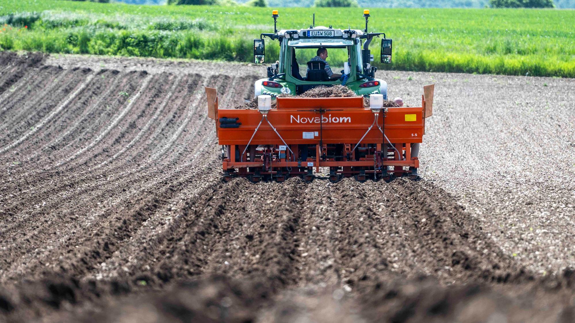 Das Bild zeigt einen Traktor, der über ein Feld fährt.
