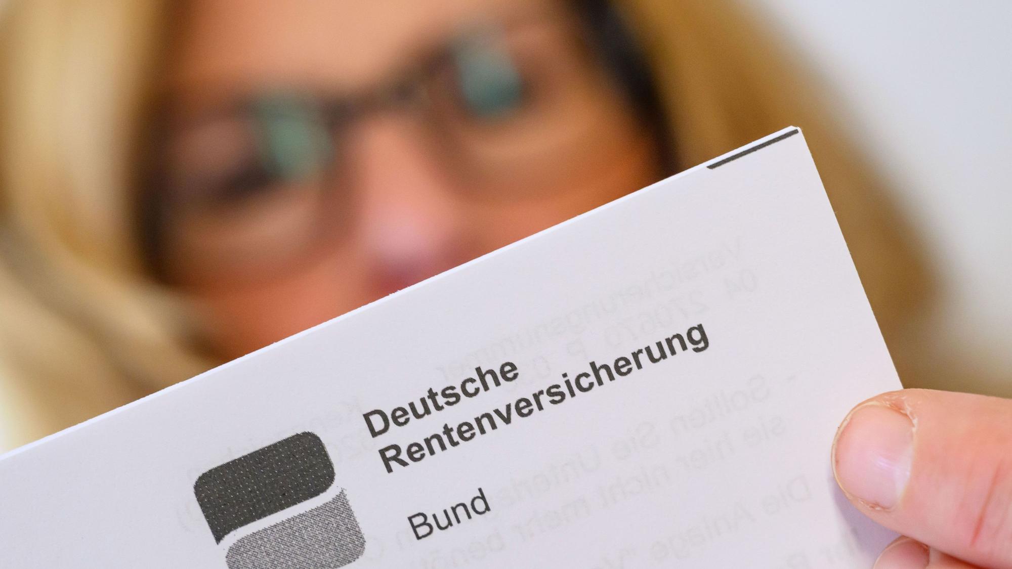 Eine Frau liest ein Schreiben der Deutschen Rentenversicherung in ihrer Wohnung. (Symbolbild)