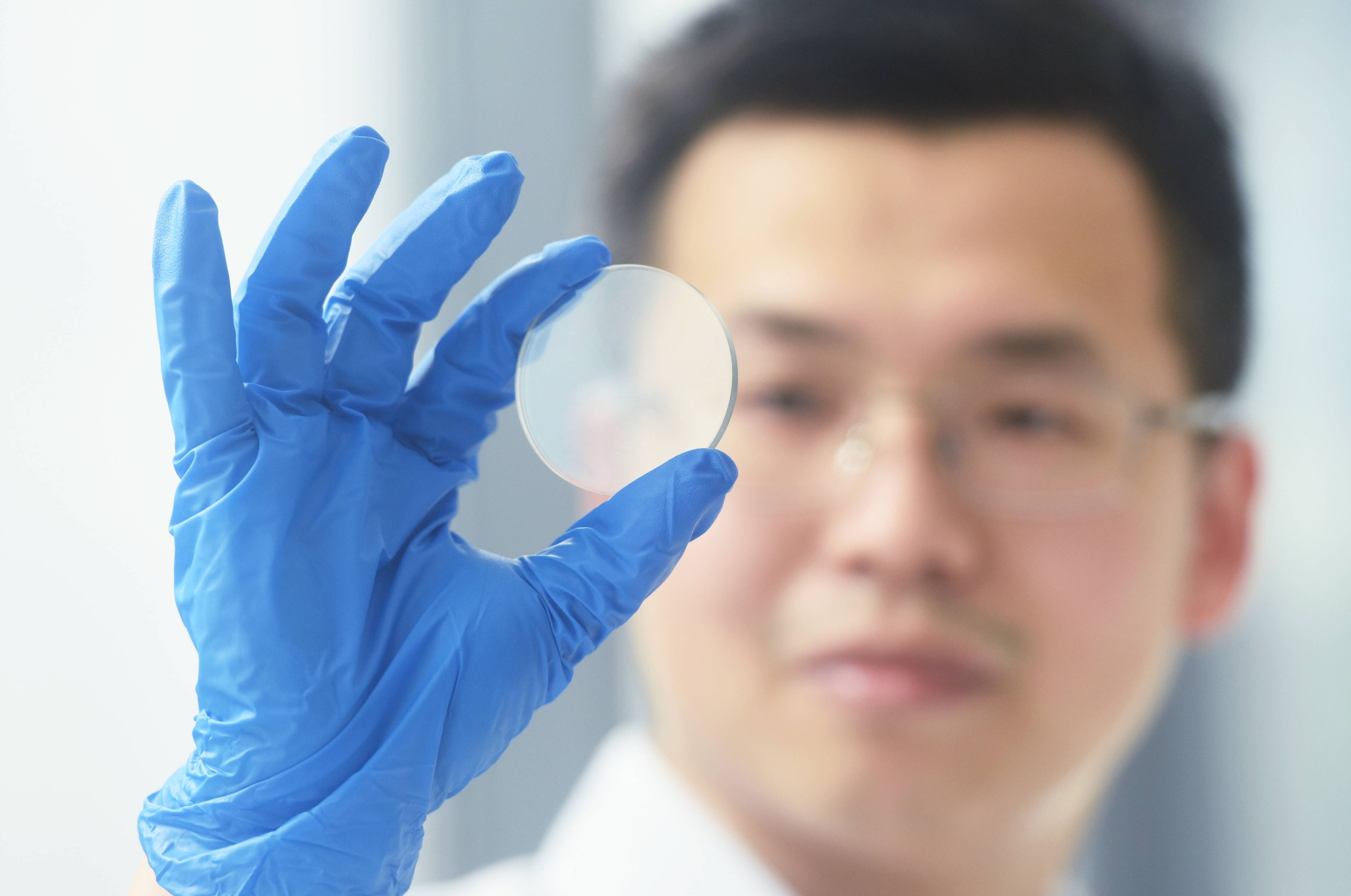 Ein Forscher der Universität Hangzhou begutachtet einen Gallium-Oxid-Wafer. Auf Basis dieses Trägers können Mikrochips hergestellt werden.