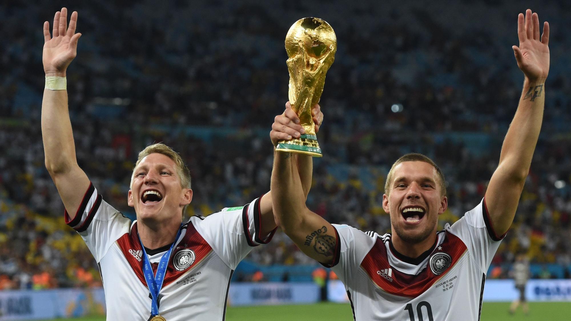 Rio De Janeiro: Bastian Schweinsteiger (l) und Lukas Podolski jubeln nach dem Sieg bei der FIFA Weltmeisterschaft 2014 mit dem Pokal.