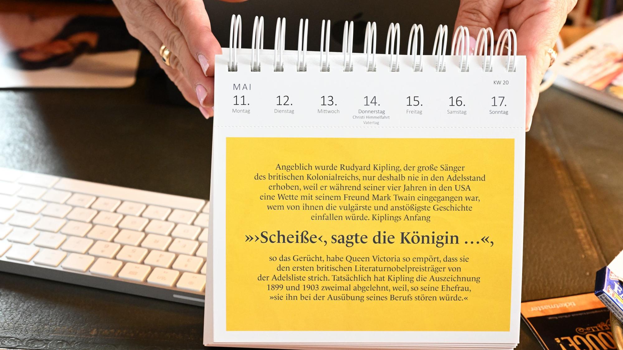 Ein gelbes Kalenderblatt mit dem Zitat: "Scheiße, sagte die Königin...".
