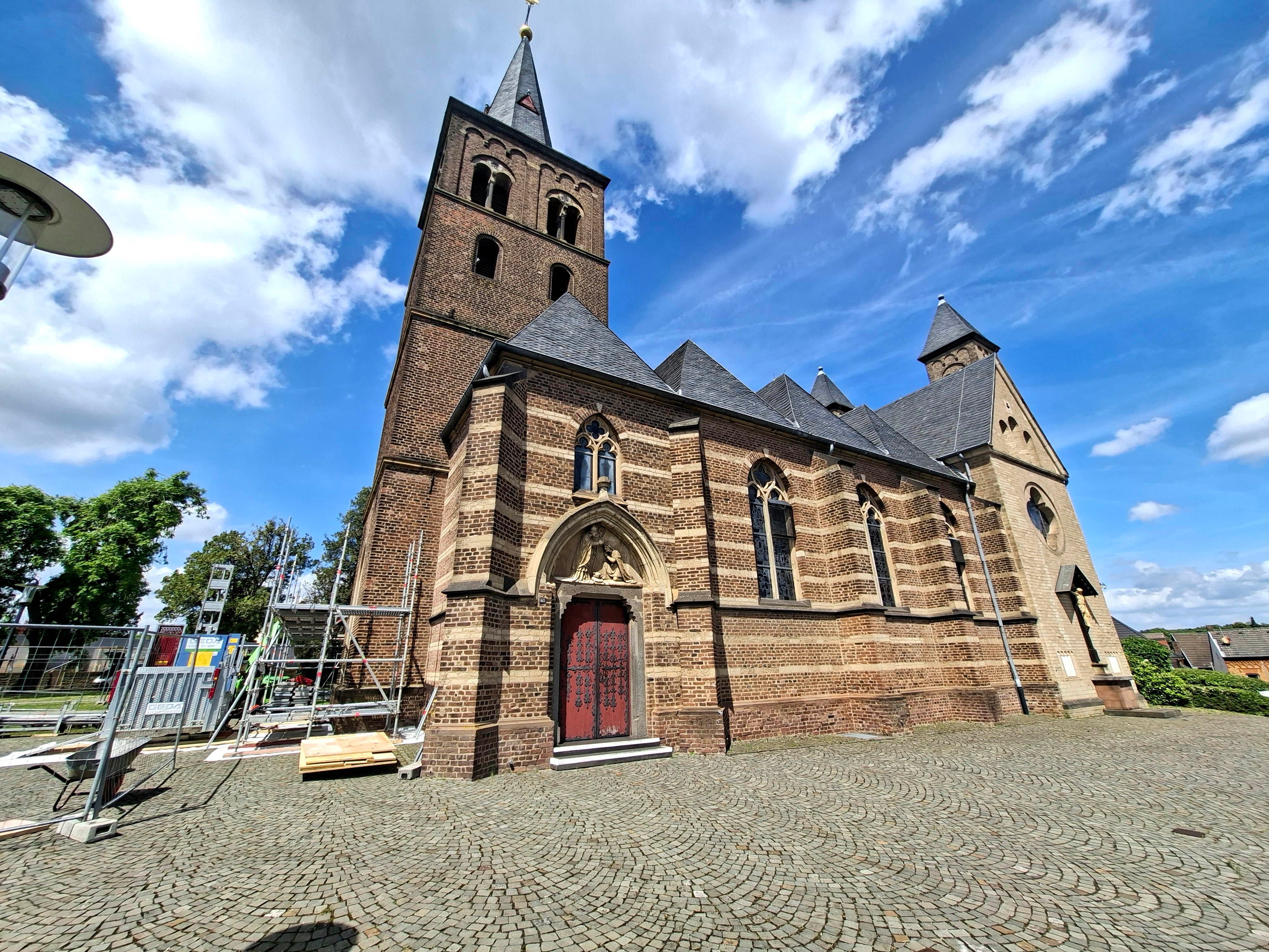Zu sehen ist die St.-Remigius-Kirche in Bergheim und davor ein Gerüst.
