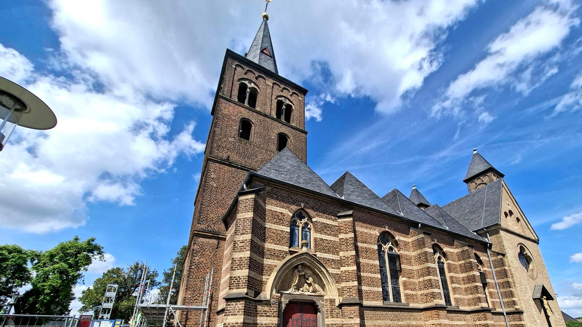 Zu sehen ist die St.-Remigius-Kirche in Bergheim und davor ein Gerüst.
