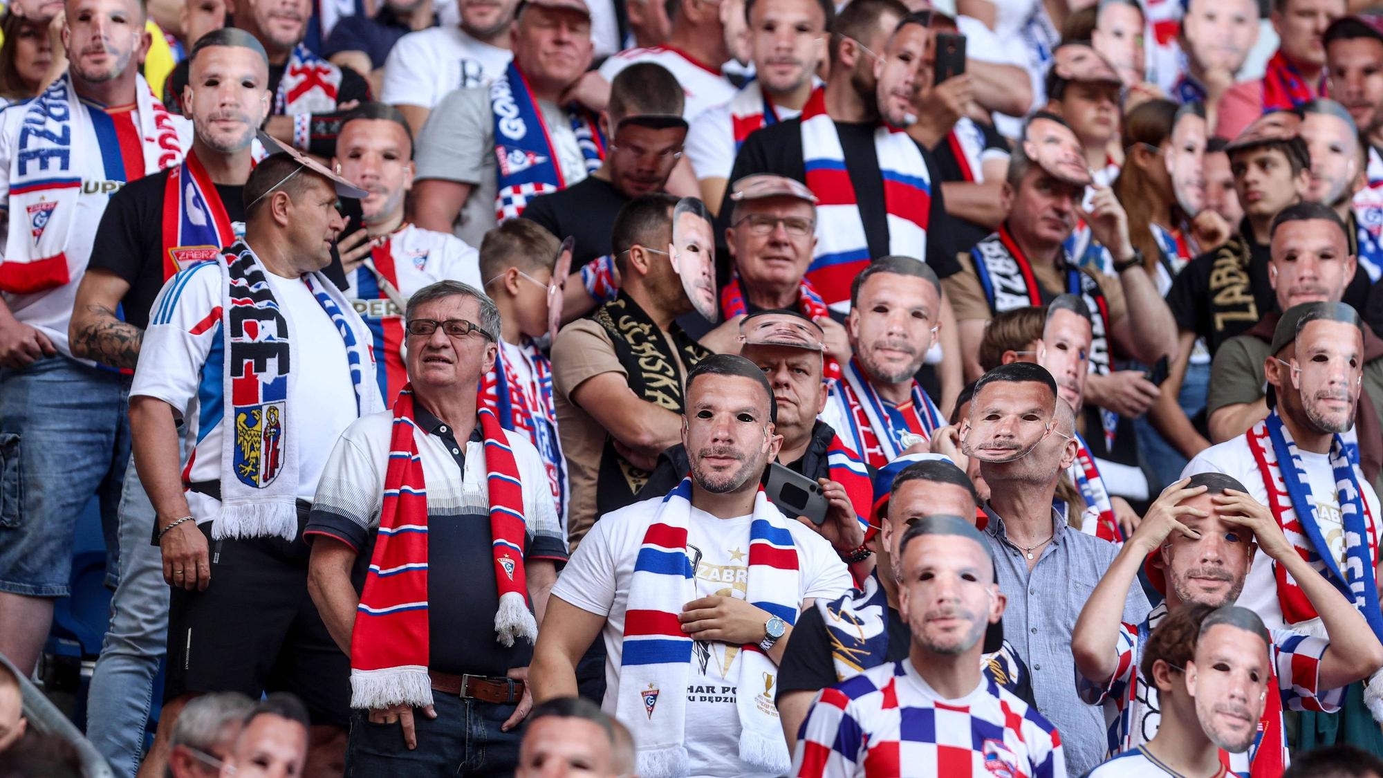 Fans mit der Maske von Lukas Podolski im Stadion.
